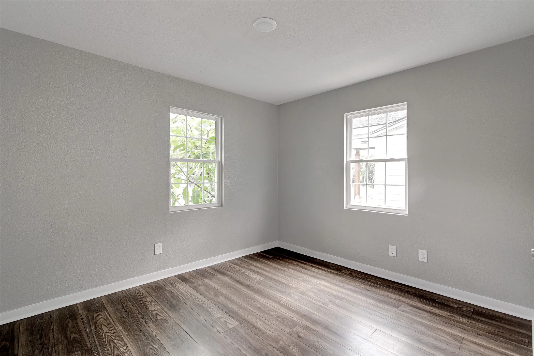 Interior room featuring wood-finish flooring, light gray painted walls, and white trim