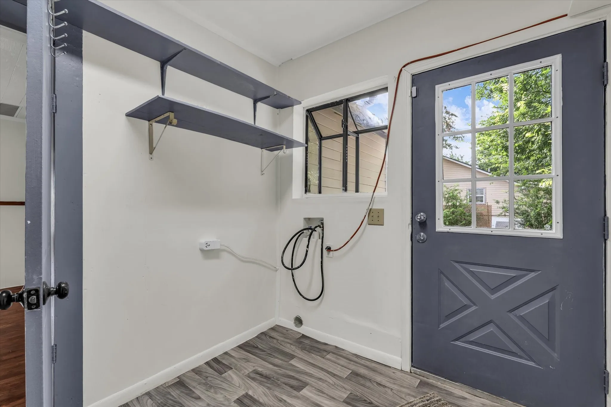 Utility space featuring tile flooring, white walls, and a bay window