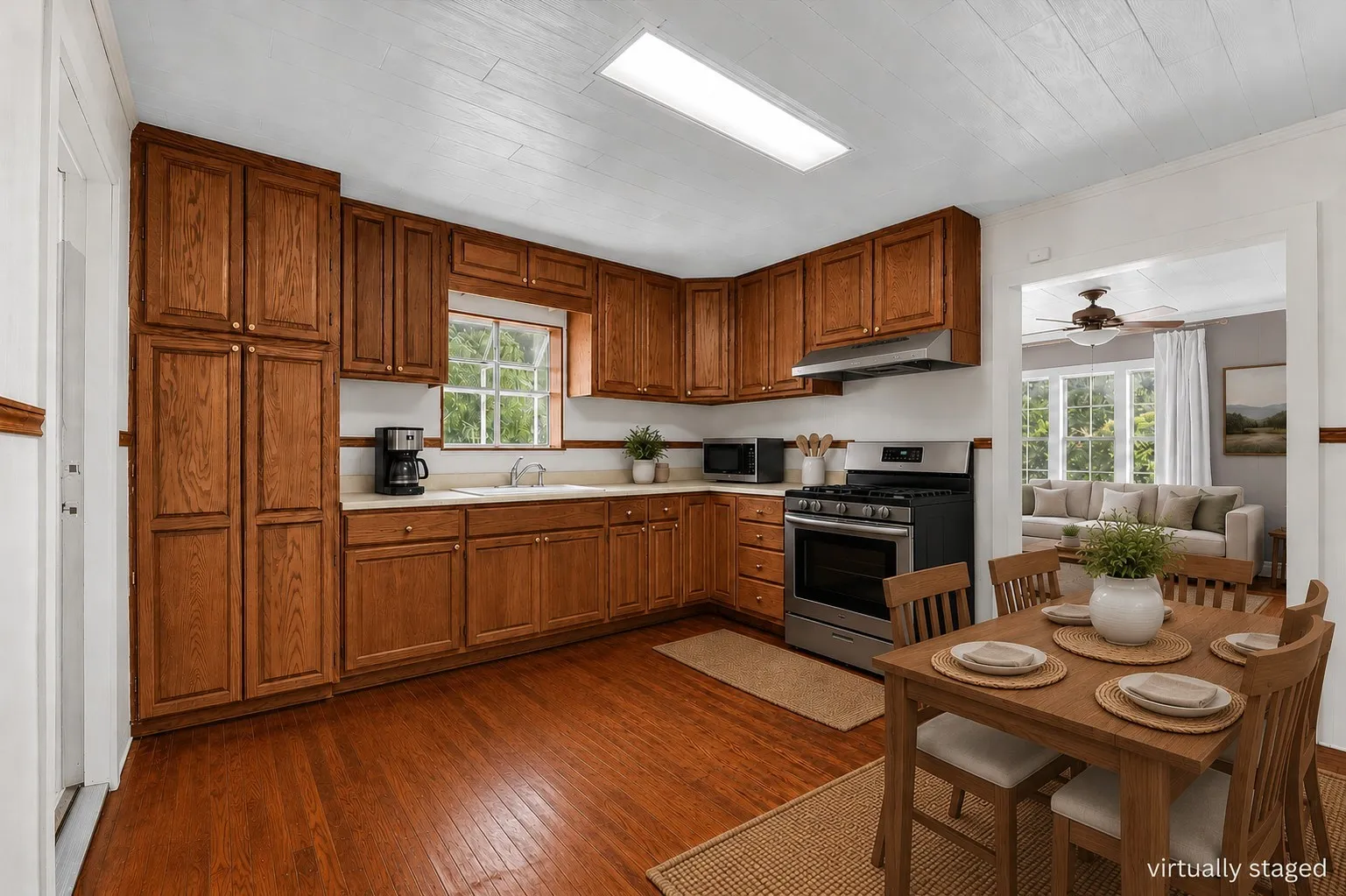 Kitchen featuring wood-finish flooring, warm-toned cabinetry, light countertops, and stainless steel appliances