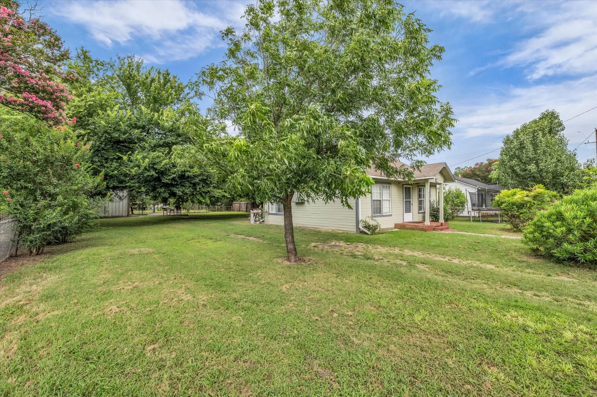Expansive green lawn with mature trees and established landscaping
