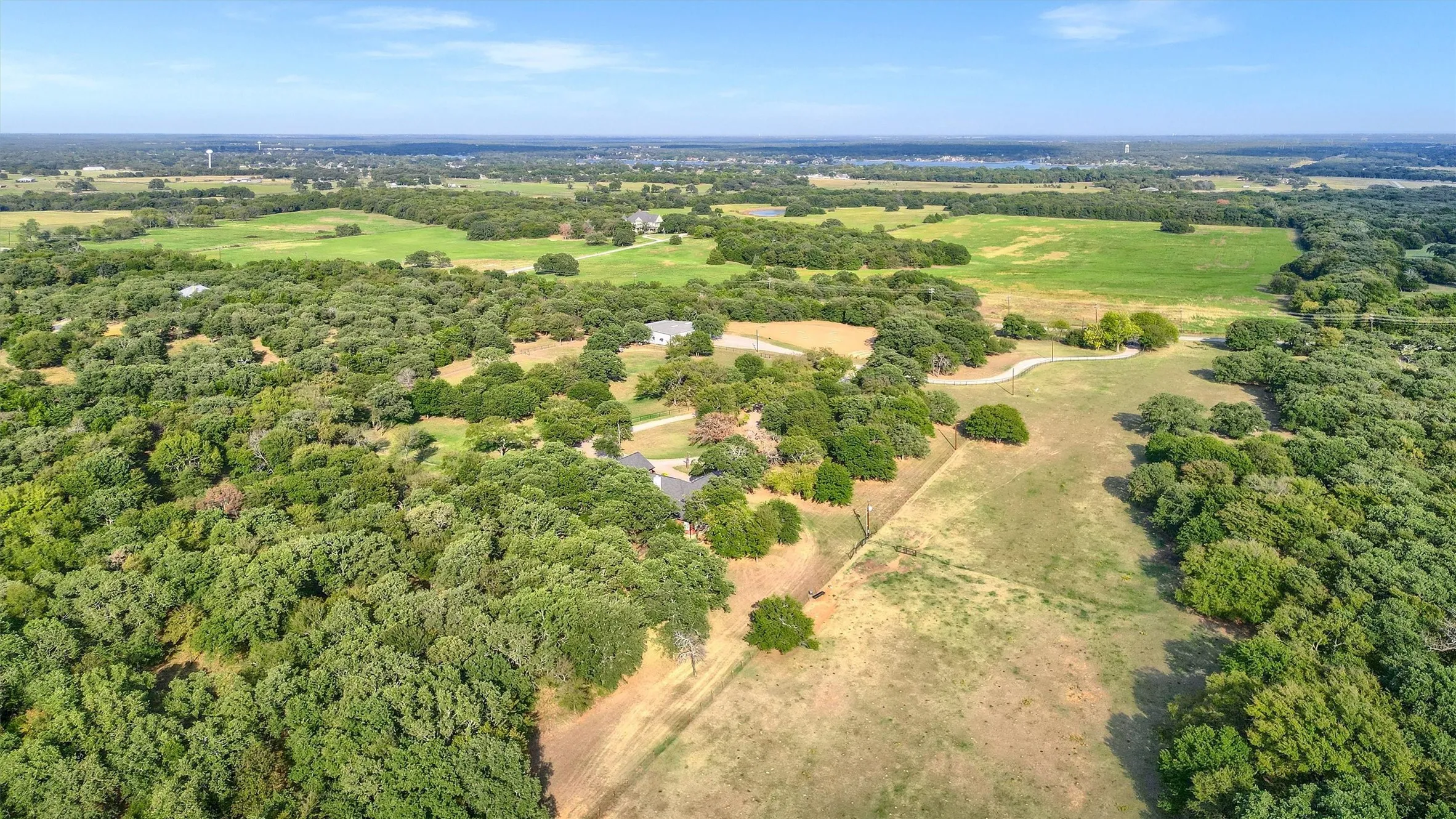 Aerial view showing the pastures and wooded areas of the property - entrance is off FM 3496.