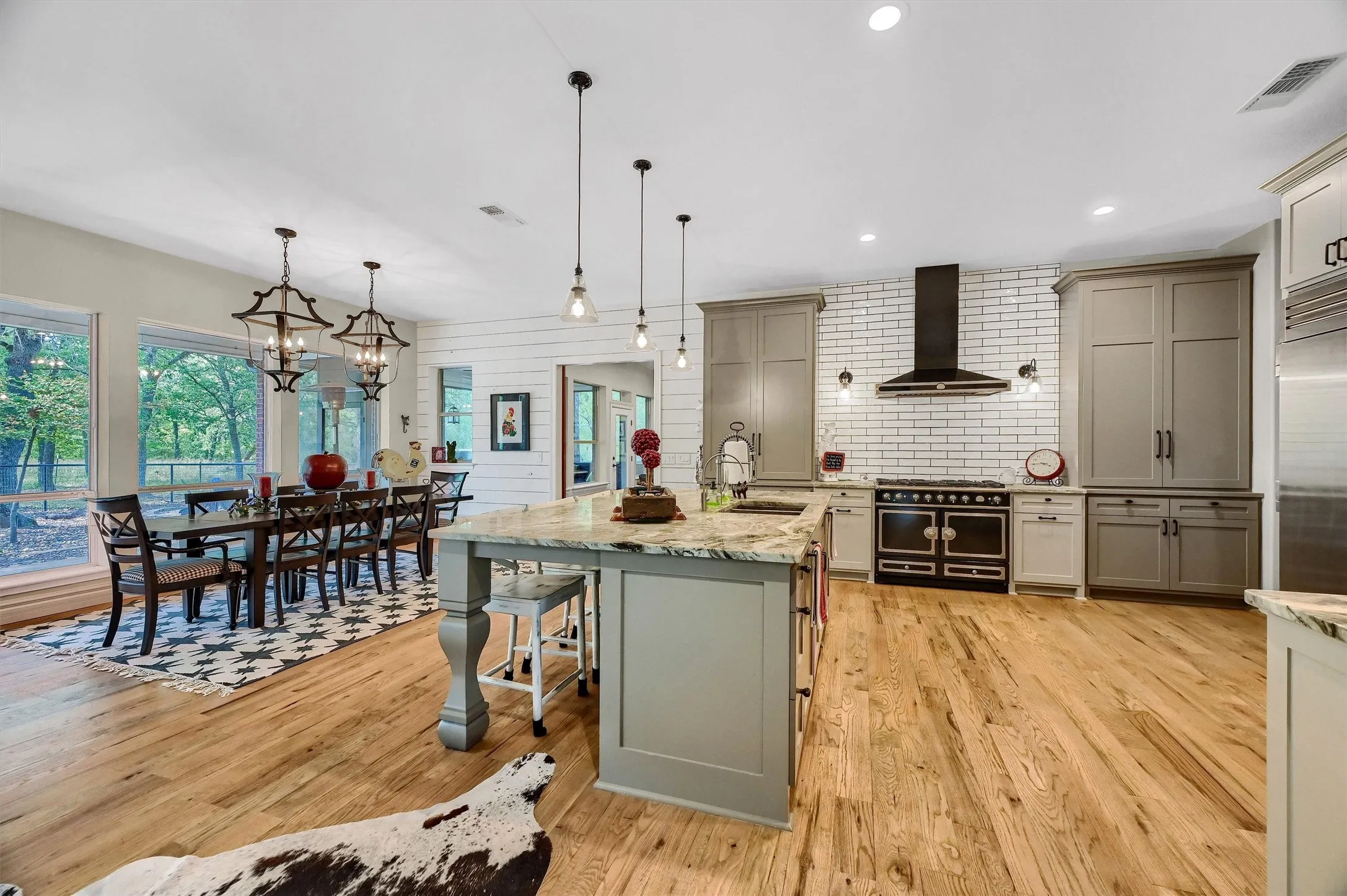 Note the spacious kitchen, with adjacent large dining area and custom chandeliers.