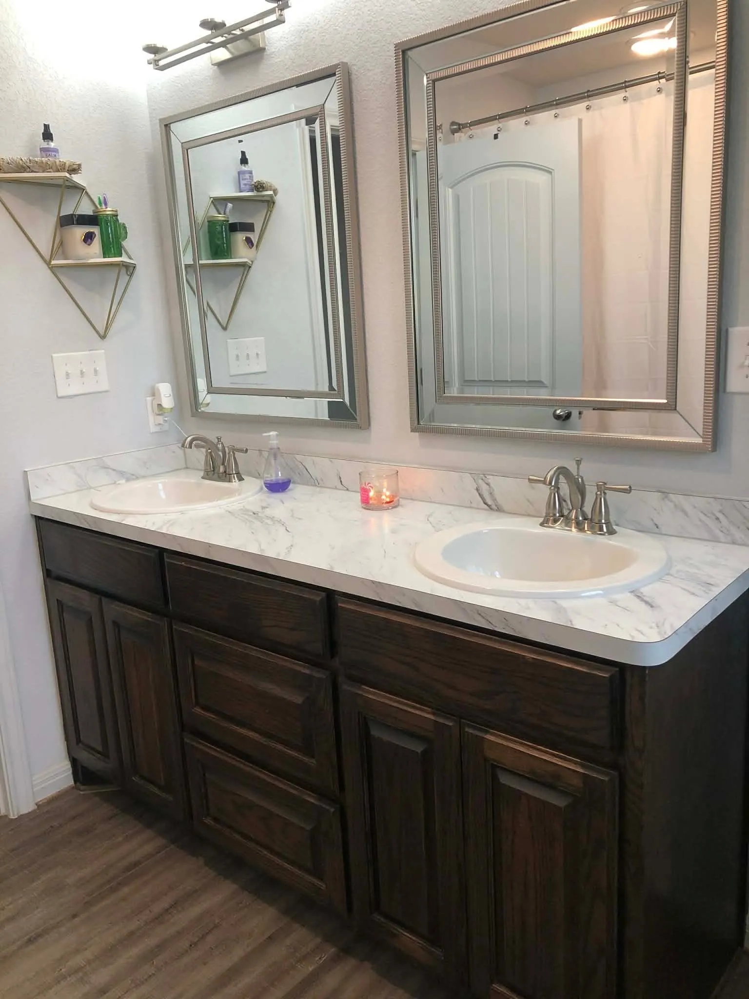 Double vanity featuring dark wood-finish cabinetry, dual undermount sinks, and a marble-look countertop