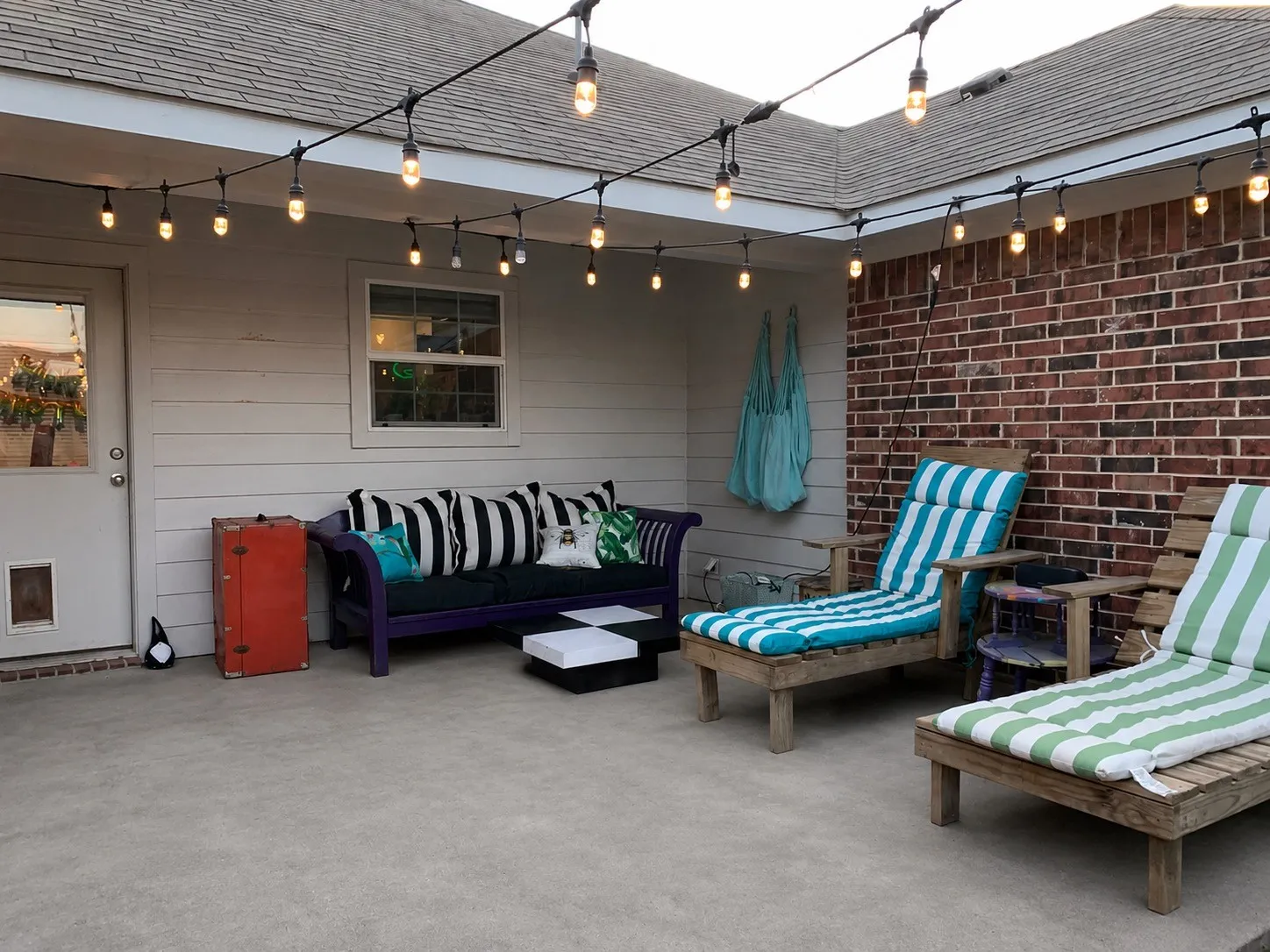 Covered patio featuring concrete flooring and string lighting