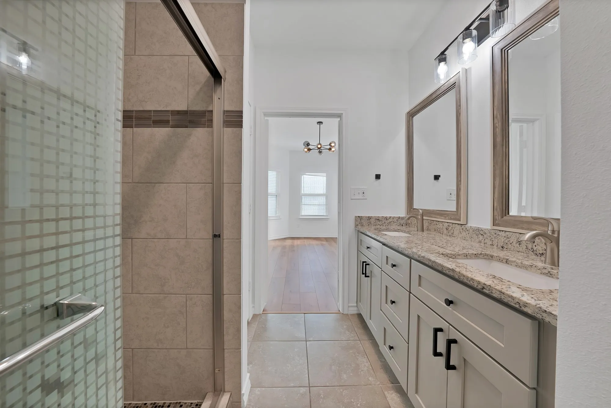 Bathroom vanity with dual undermount sinks and light-toned stone countertops