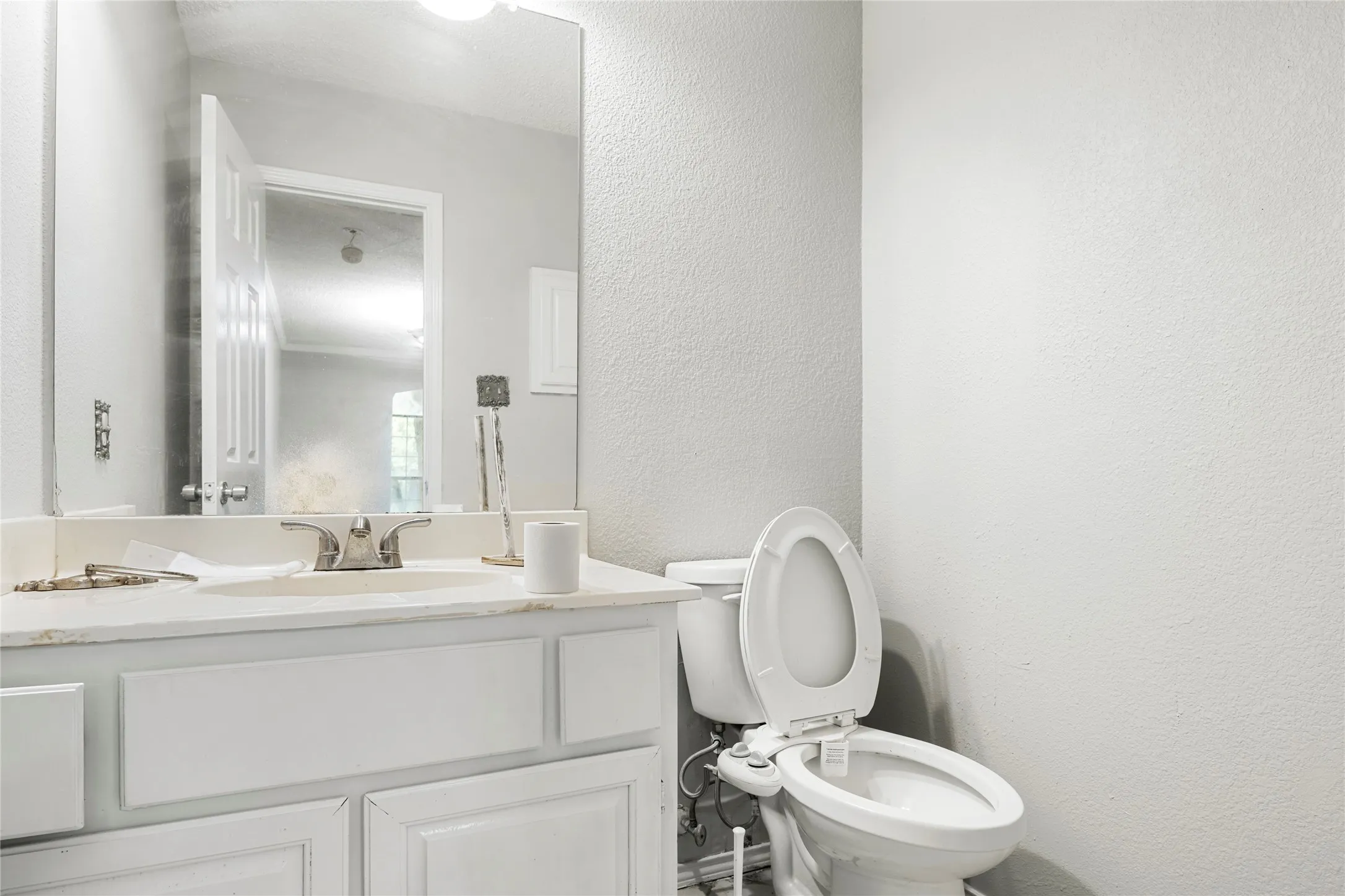 Bathroom vanity featuring an integrated sink, dual-handle faucet, and white cabinetry
