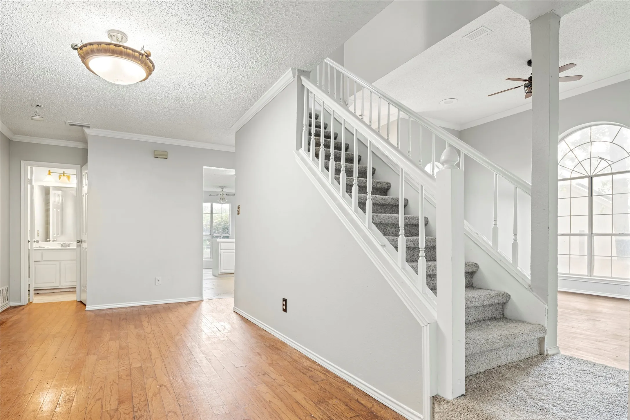 Carpeted staircase with white balusters and handrails