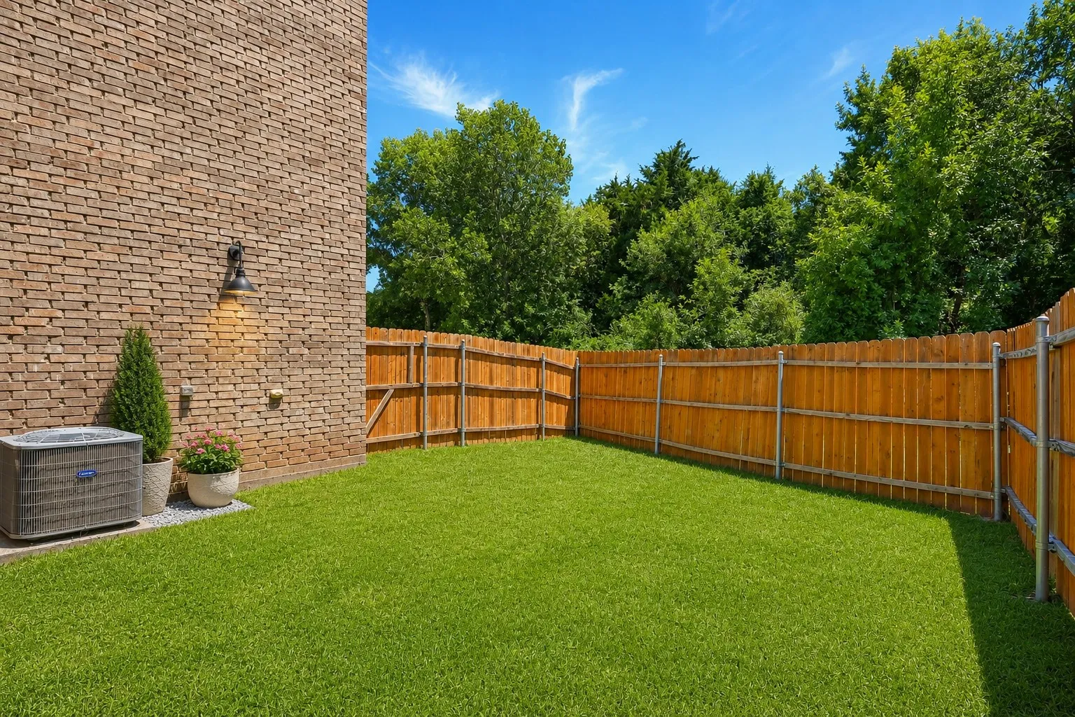 Private backyard featuring a well-maintained lawn and a wooden privacy fence
