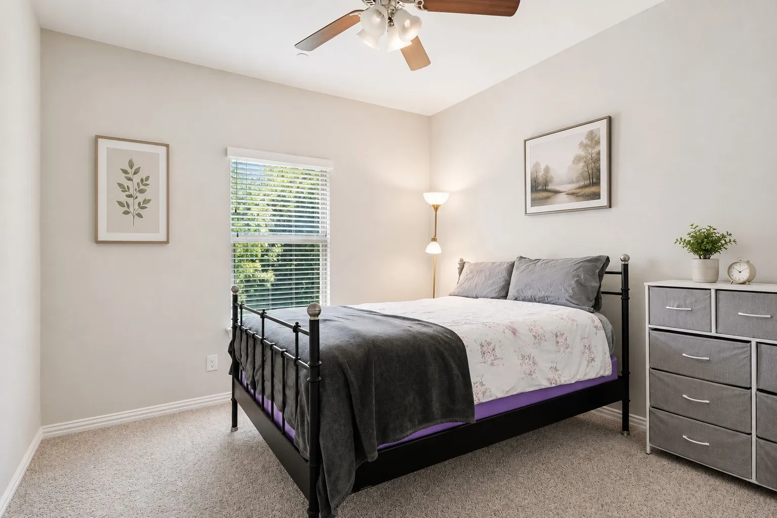 Carpeted room with a ceiling fan featuring a window with blinds, light-toned walls, and white baseboards