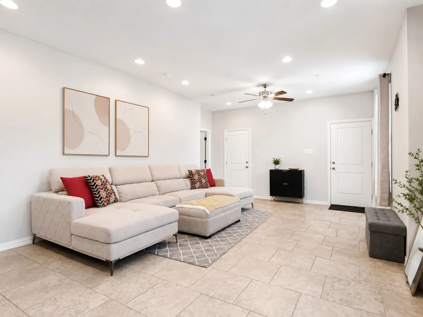 Spacious living area featuring large format tile flooring, recessed ceiling lighting, a ceiling fan fixture, and light-toned wall finishes