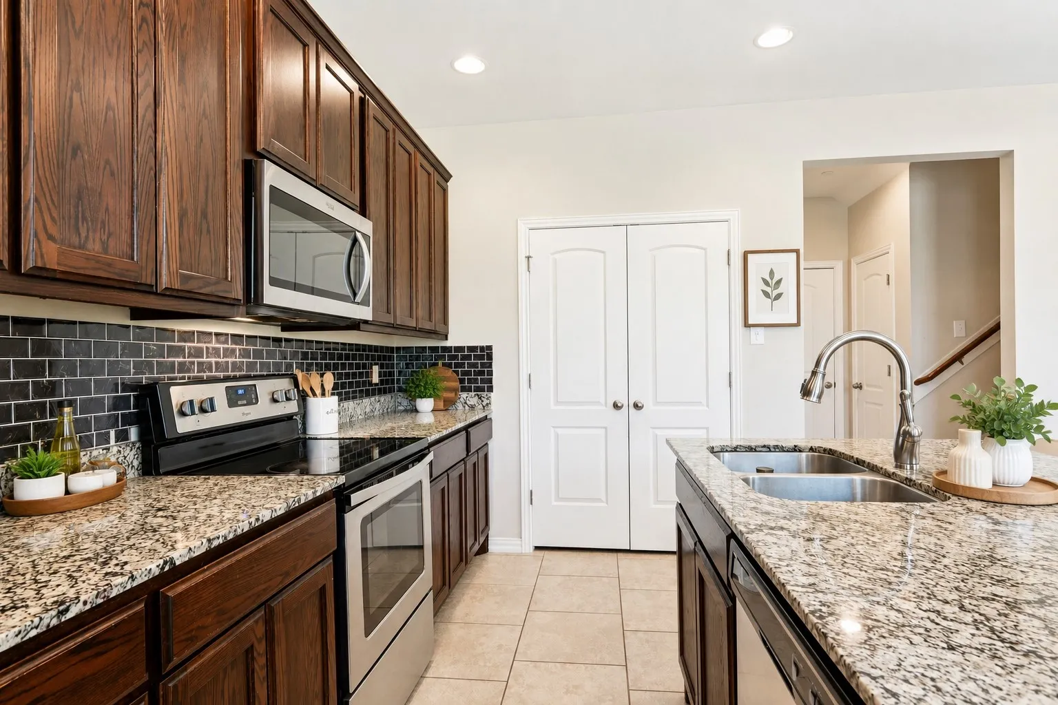 Kitchen featuring granite countertops, dark wood-finish cabinetry, stainless steel appliances, and a black tile backsplash