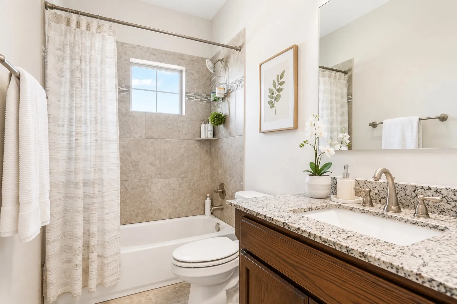 Full bathroom featuring a tub/shower combination, window-inset shower tile, a vanity with a granite countertop, and brushed nickel fixtures