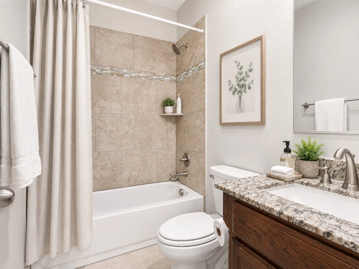 Bathroom featuring a shower-tub combination with tile surround and decorative accent band