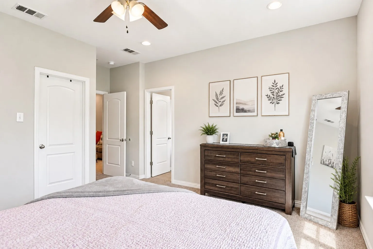 Neutral wall finishes complement the carpeted flooring and white trim