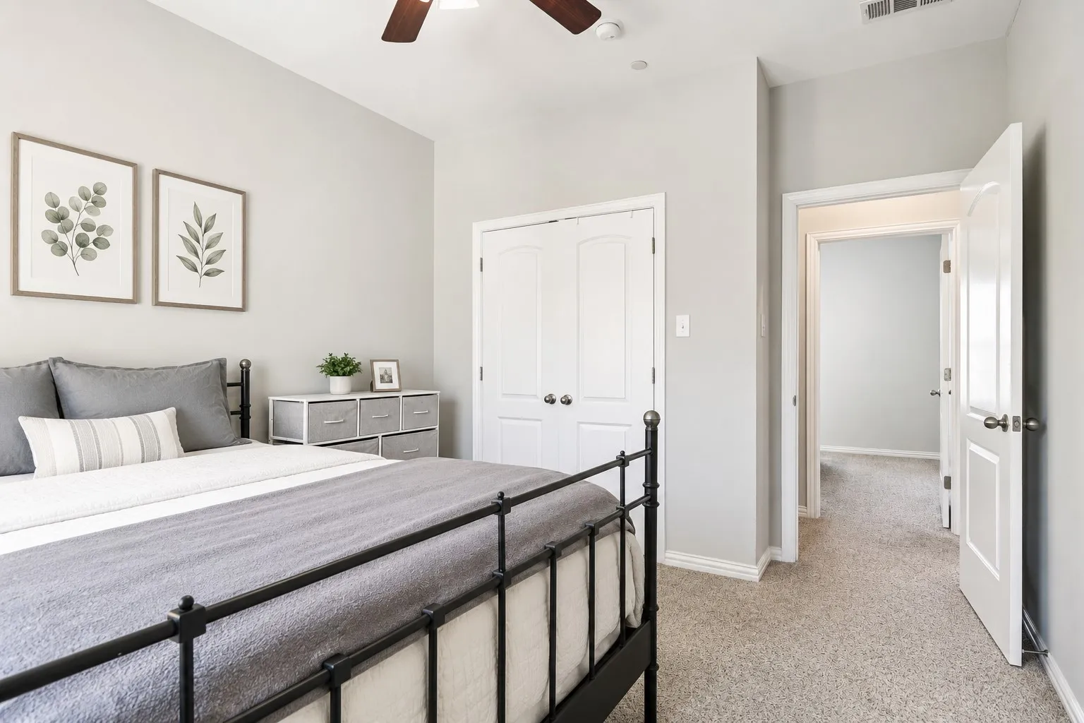 Bedroom featuring light gray walls, plush carpet, white baseboards, and a ceiling fan with a dark wood finish