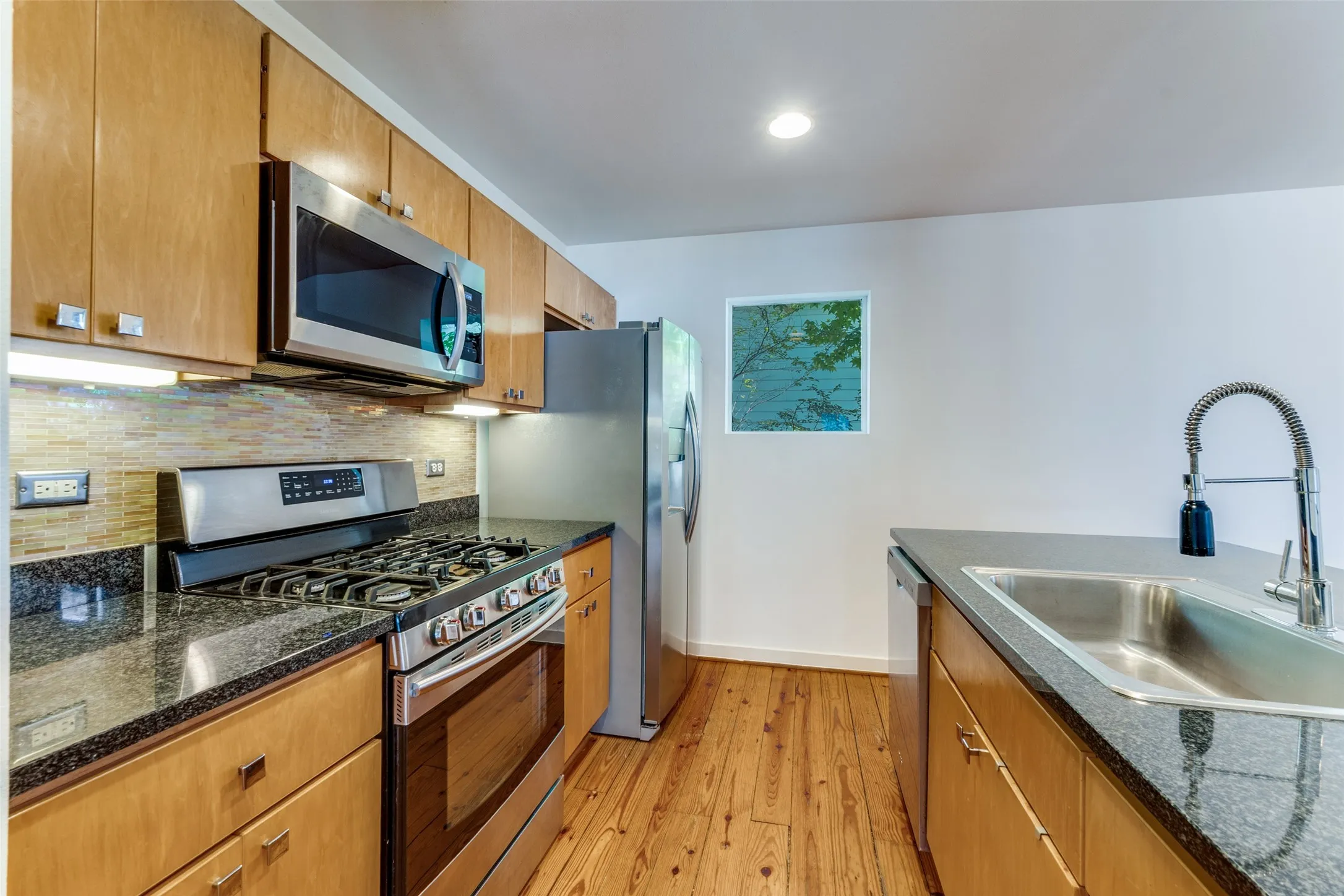 Stainless appliances including gas range, refrigerator, dishwasher and microwave.