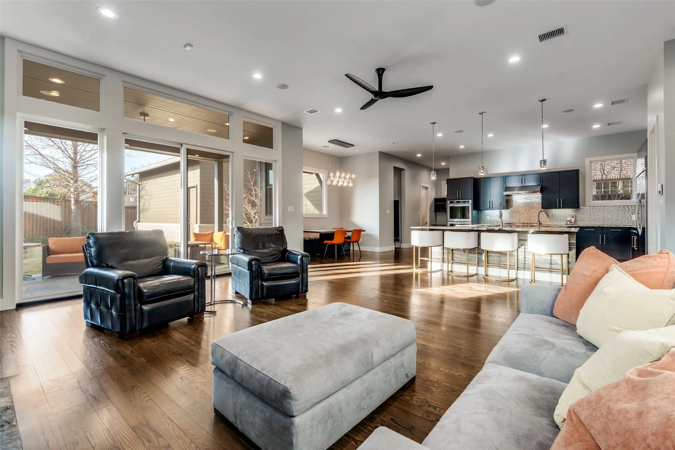 Open-concept living area featuring rich wood-finish flooring, recessed lighting, and a modern ceiling fan