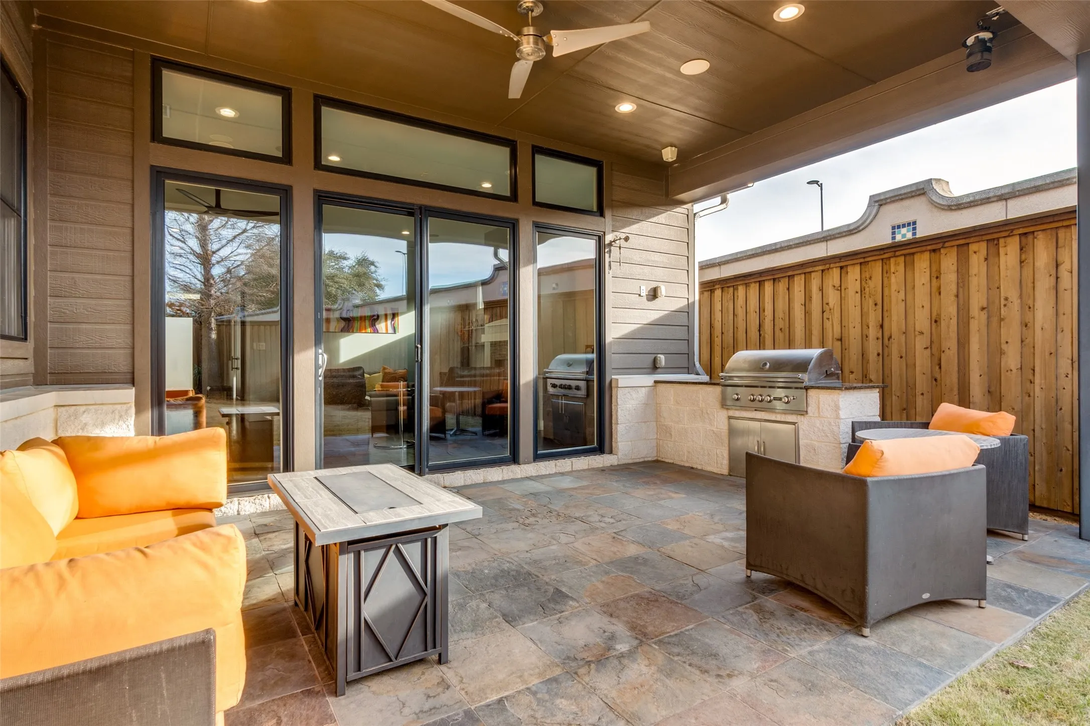 Covered patio featuring slate tile flooring and a built-in outdoor kitchen with a stainless steel grill
