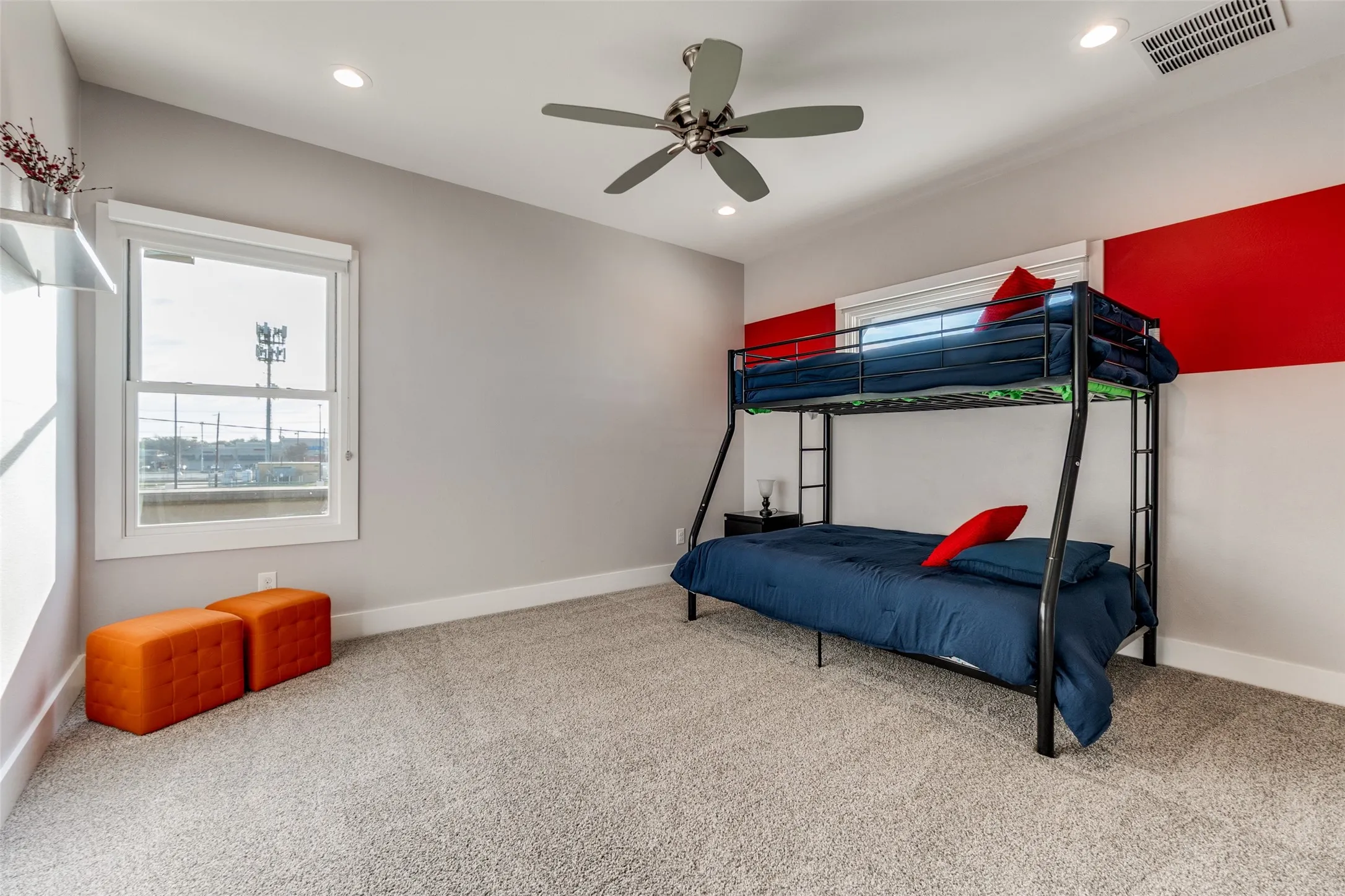 Carpeted kid's room featuring a ceiling fan with integrated lighting, recessed ceiling lights, and an accent wall with red paneling