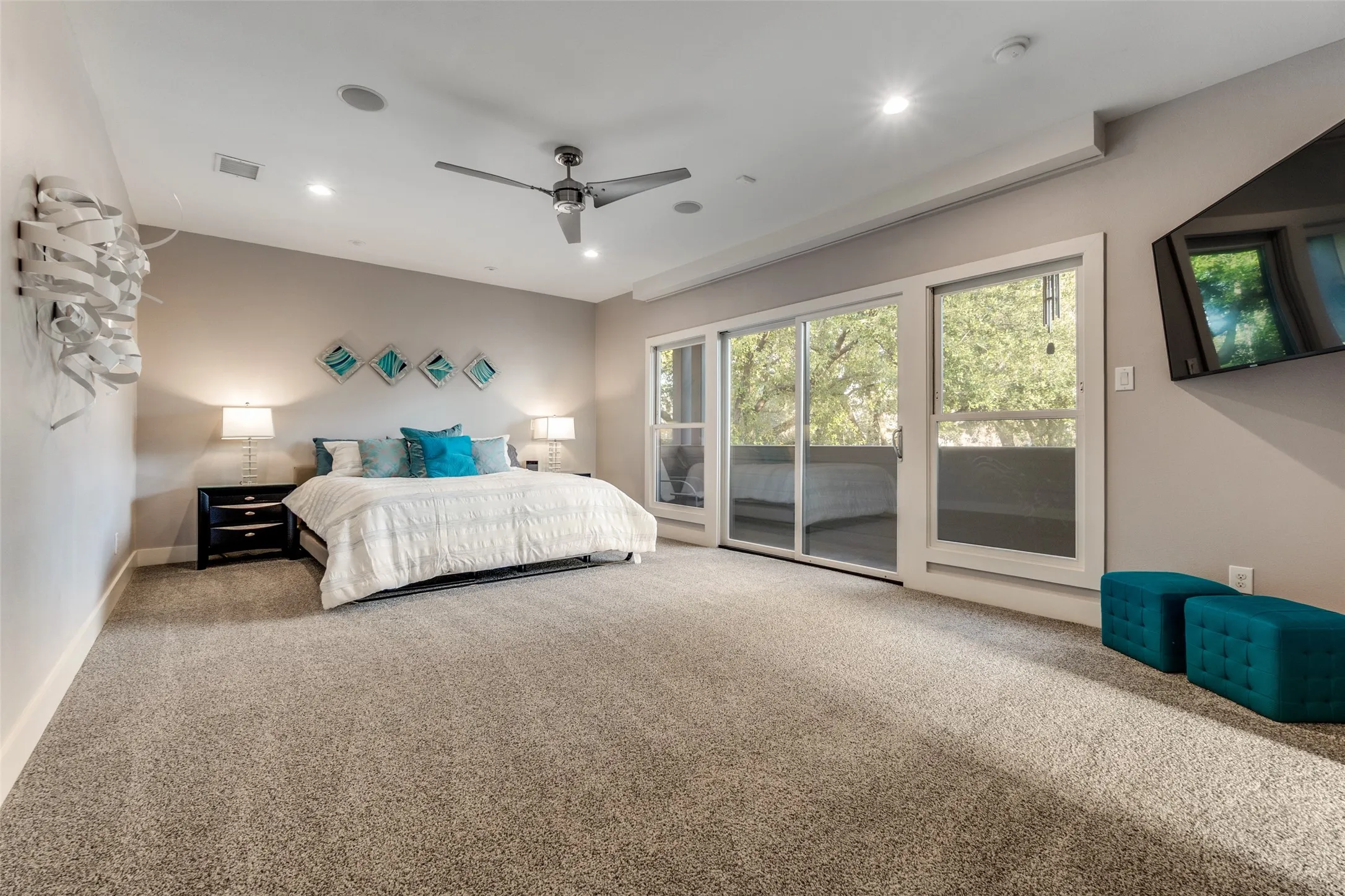 Over sized room featuring broadloom carpet, a ceiling fan, recessed lighting, and a wall-mounted flat-screen television