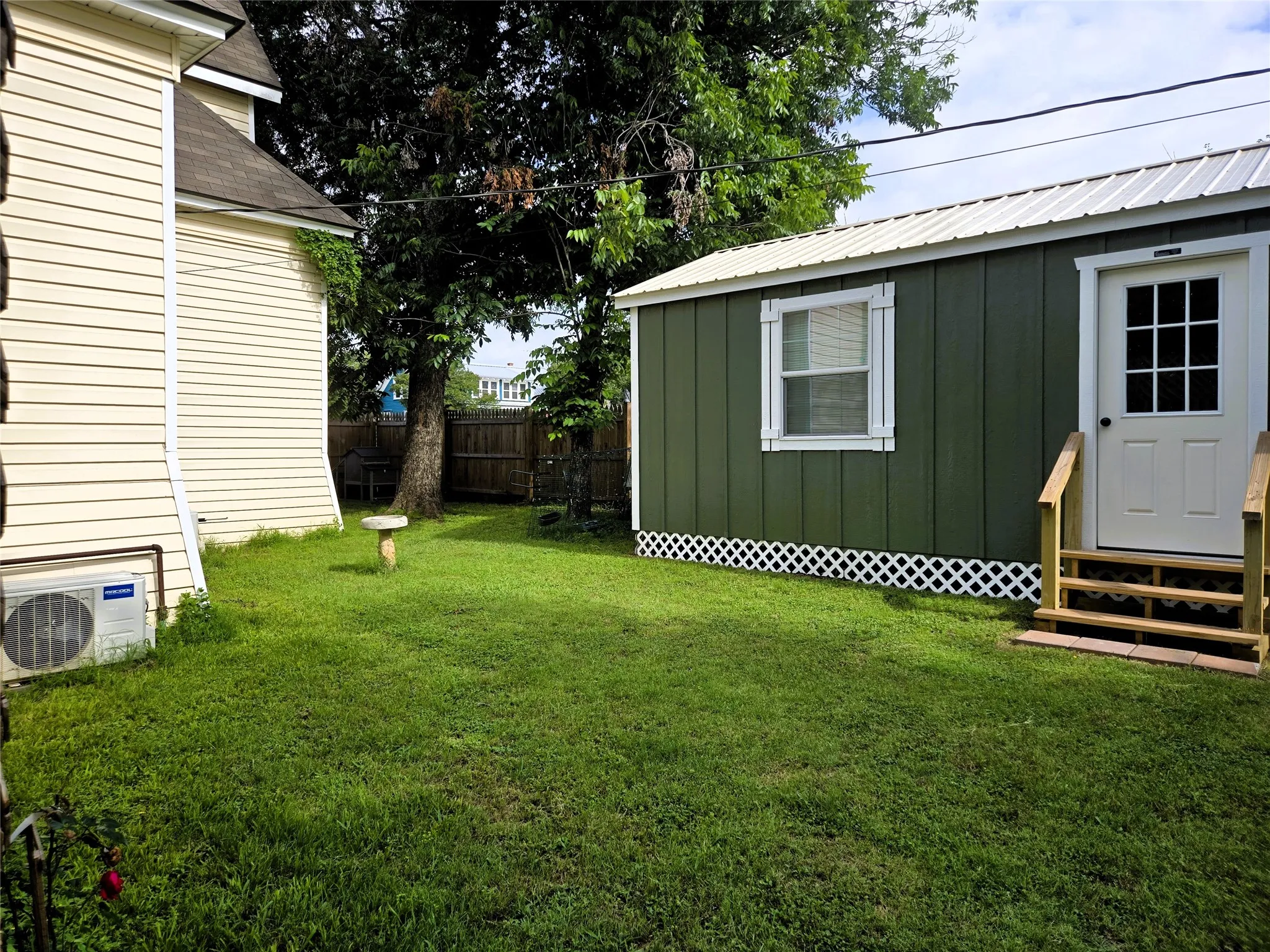 Back yard with front entrance of she shed.