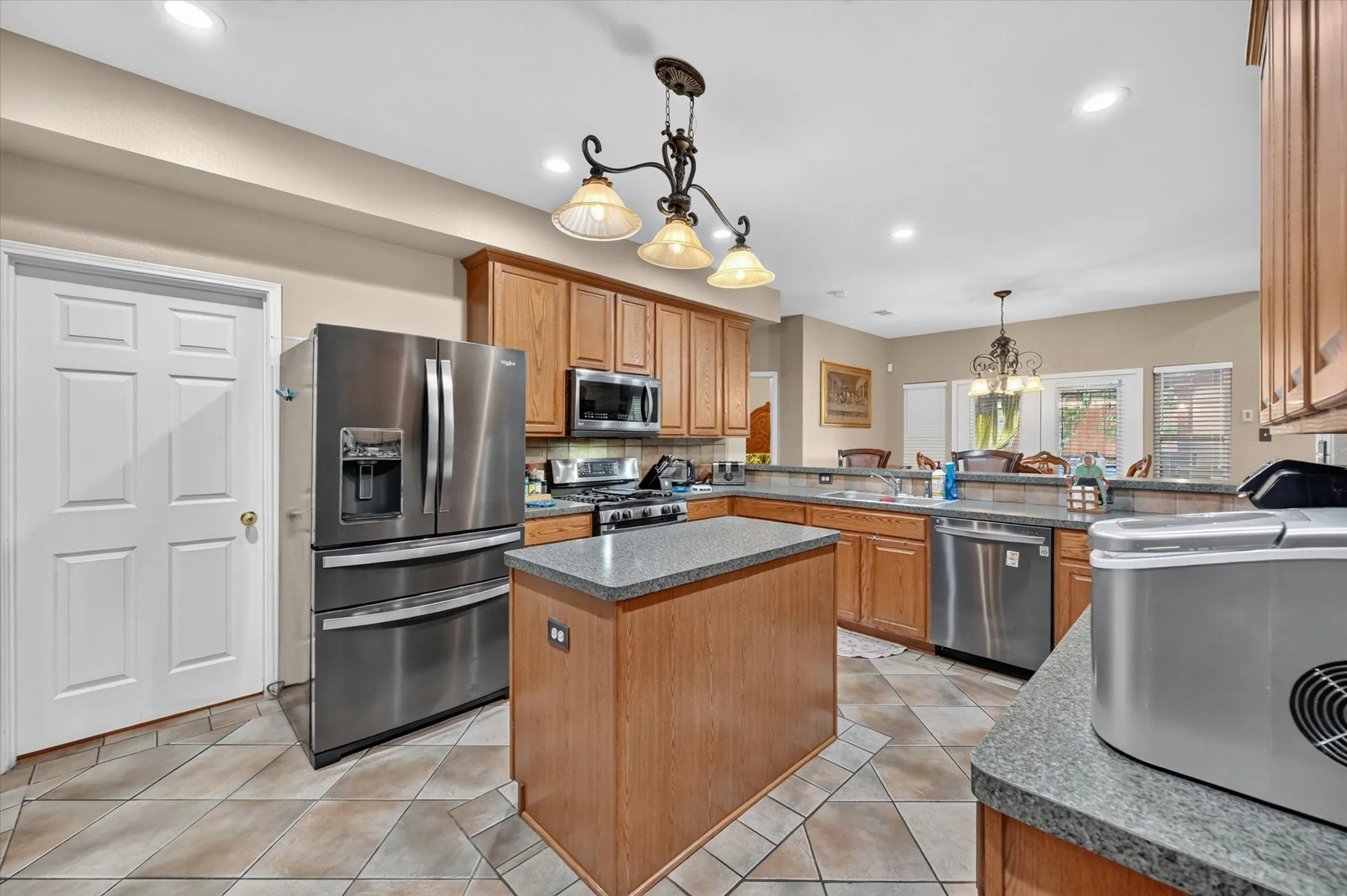 Kitchen featuring a central island, stainless steel appliances, tile flooring, and recessed lighting
