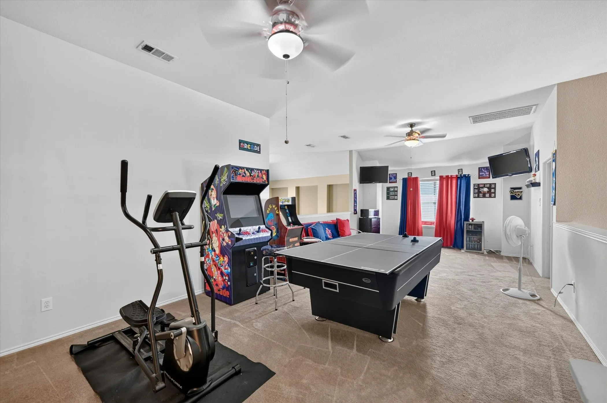 Spacious bonus room featuring vaulted ceilings, carpet flooring, and multiple ceiling fans