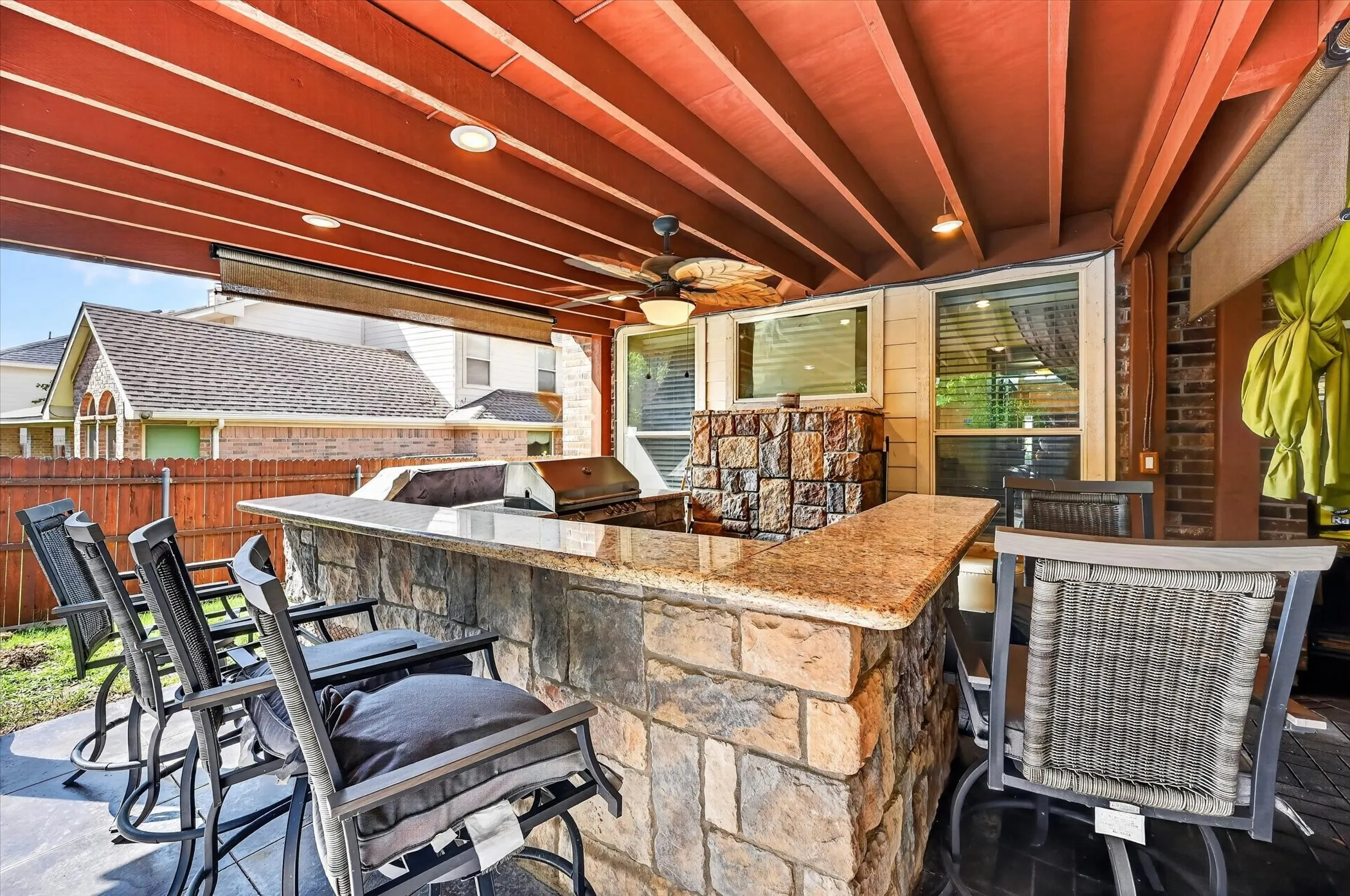 Covered patio featuring a built-in stone and granite outdoor kitchen with a grill, ceiling fan, and recessed lighting