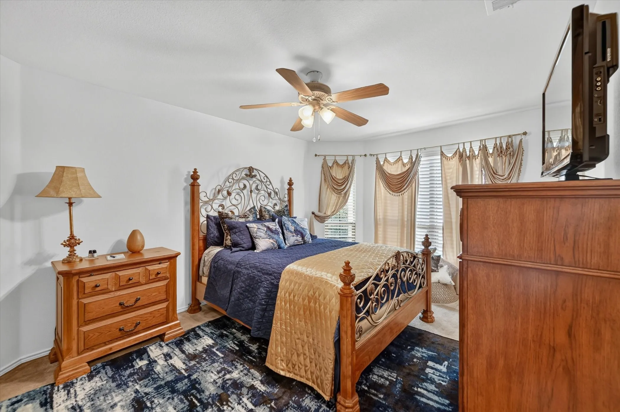 Interior space featuring a bay window with natural light, a ceiling fan fixture, and light-toned walls