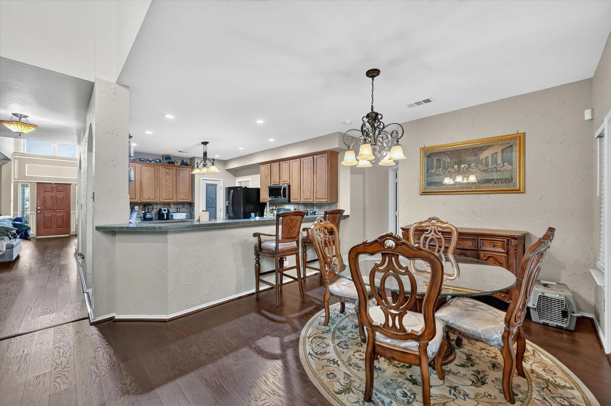 Open concept living area with dark wood-finish flooring extending into the entry