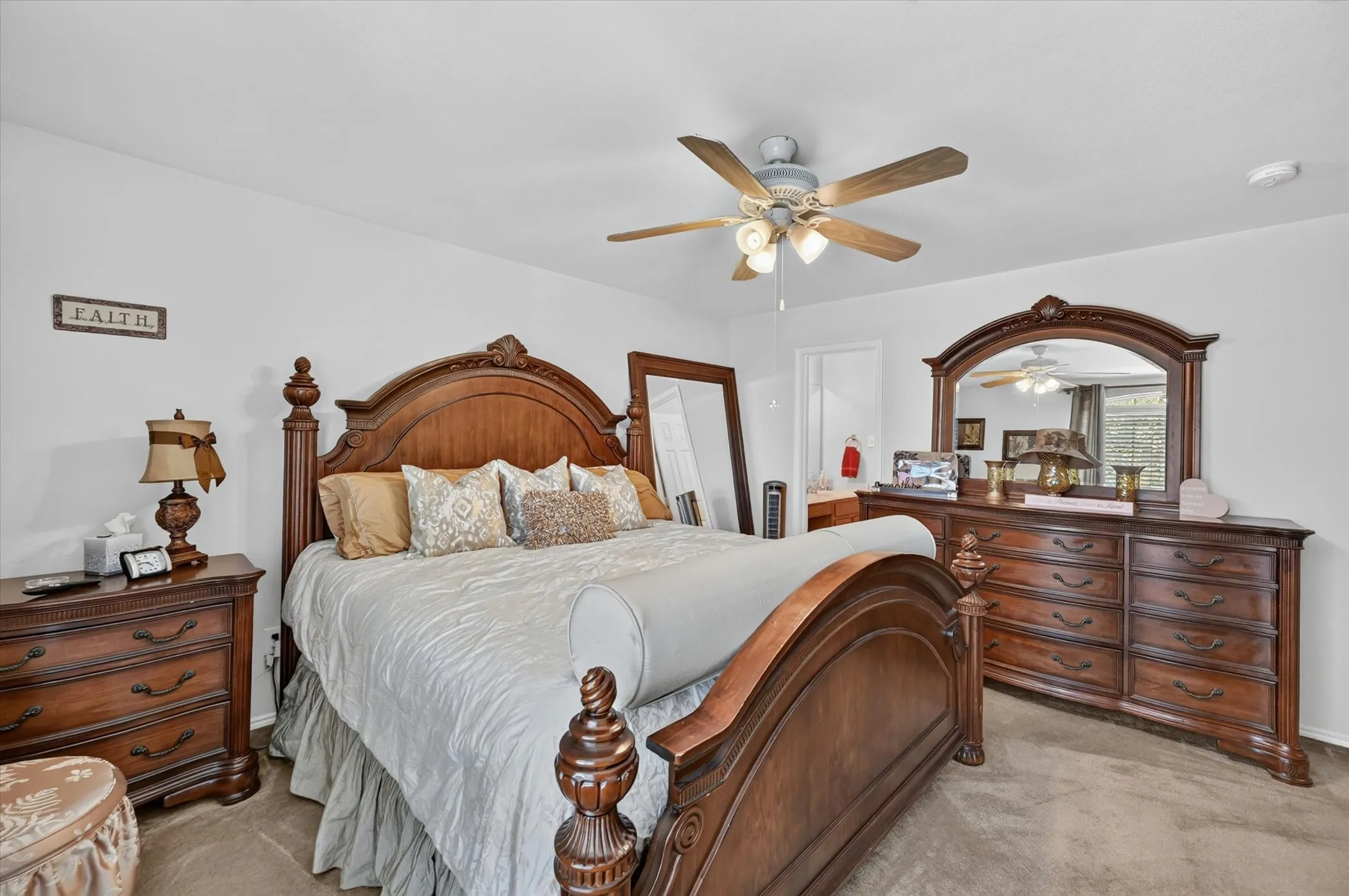 Carpeted interior space featuring a ceiling fan with integrated lighting, white walls, and a doorway