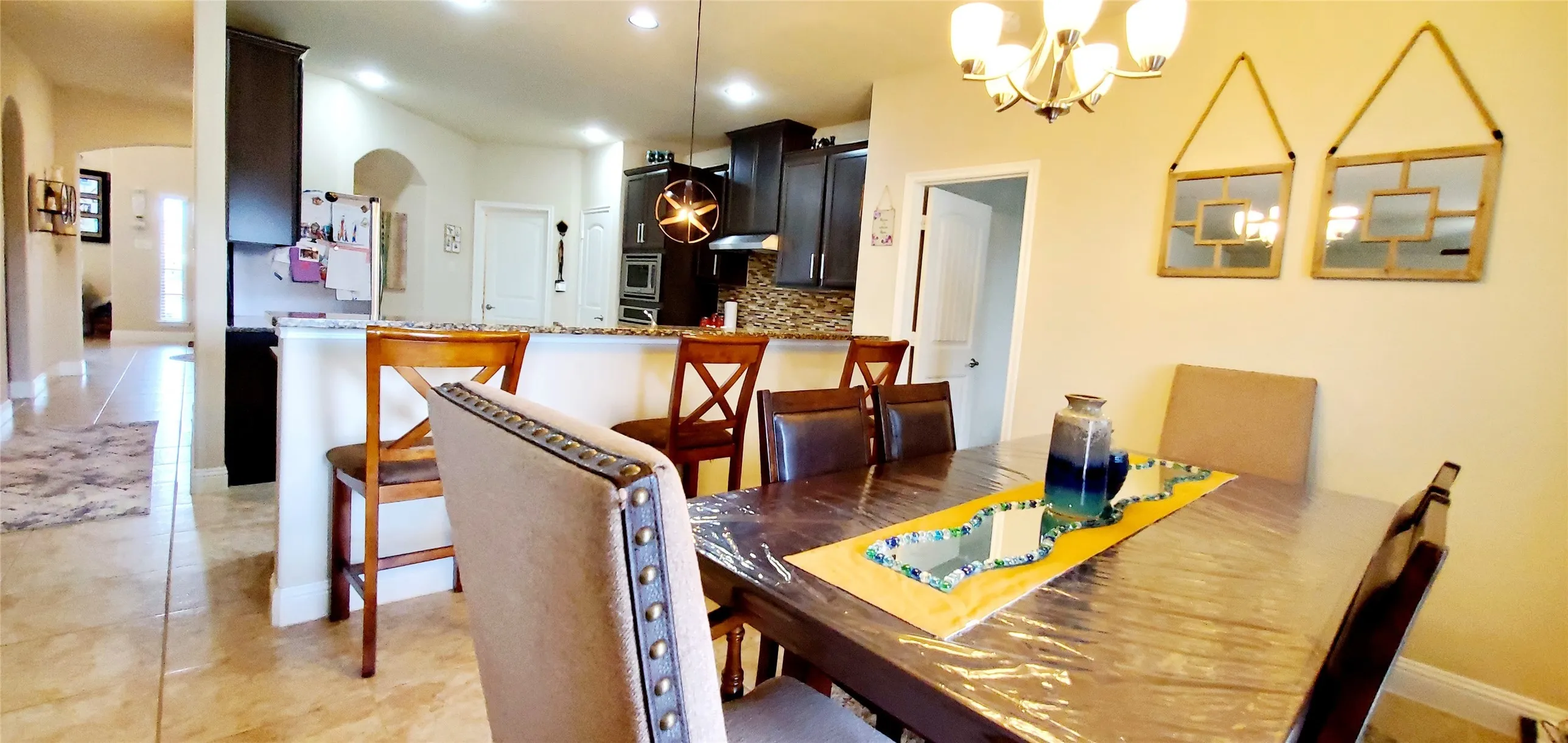 Dining area featuring a chandelier, a dark wood-finish table, and a neutral-toned upholstered chair