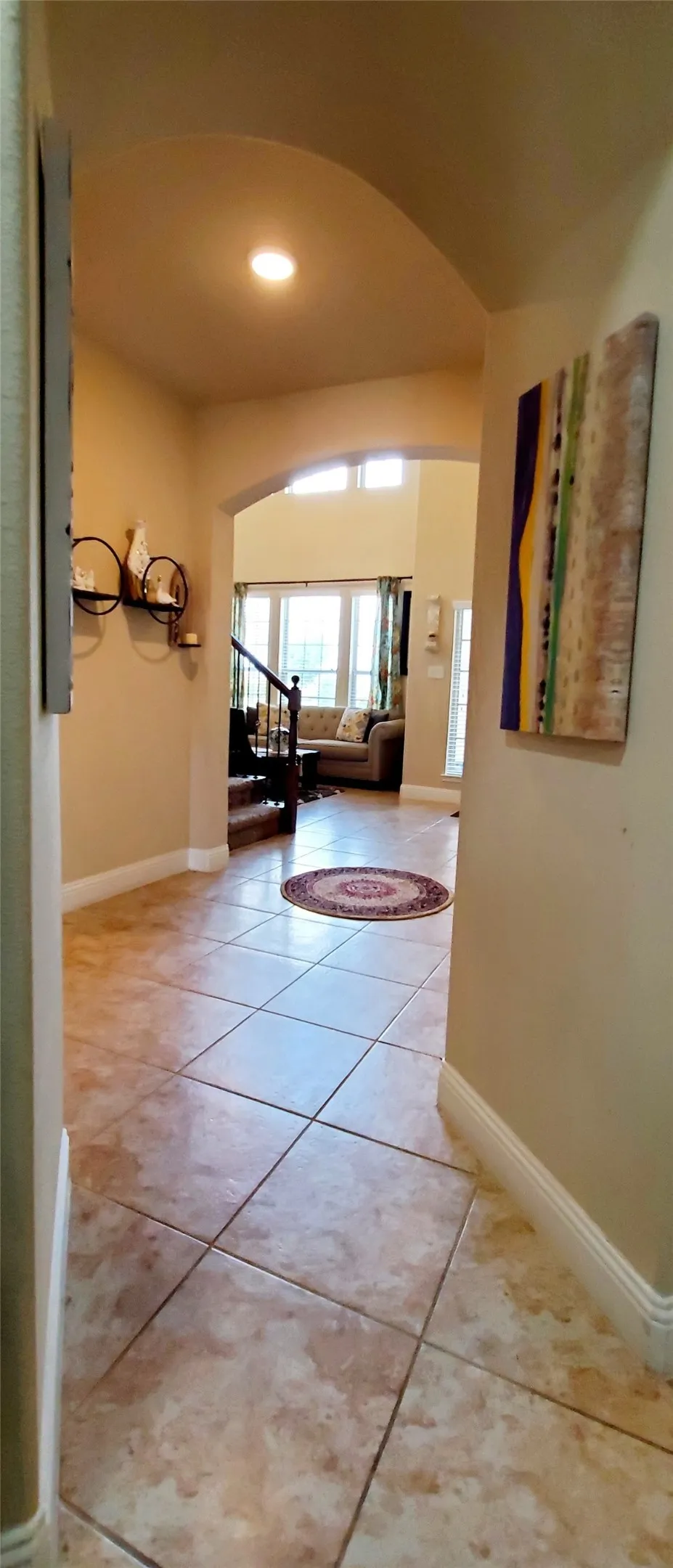 Entryway featuring large format square tile flooring and arched doorways