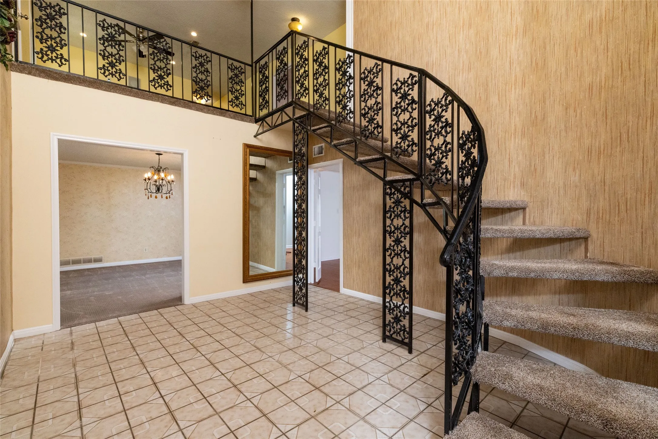 12 x 14.9 Entry foyer featuring ceramic tile flooring and a spiral staircase with ornate black wrought iron railing
