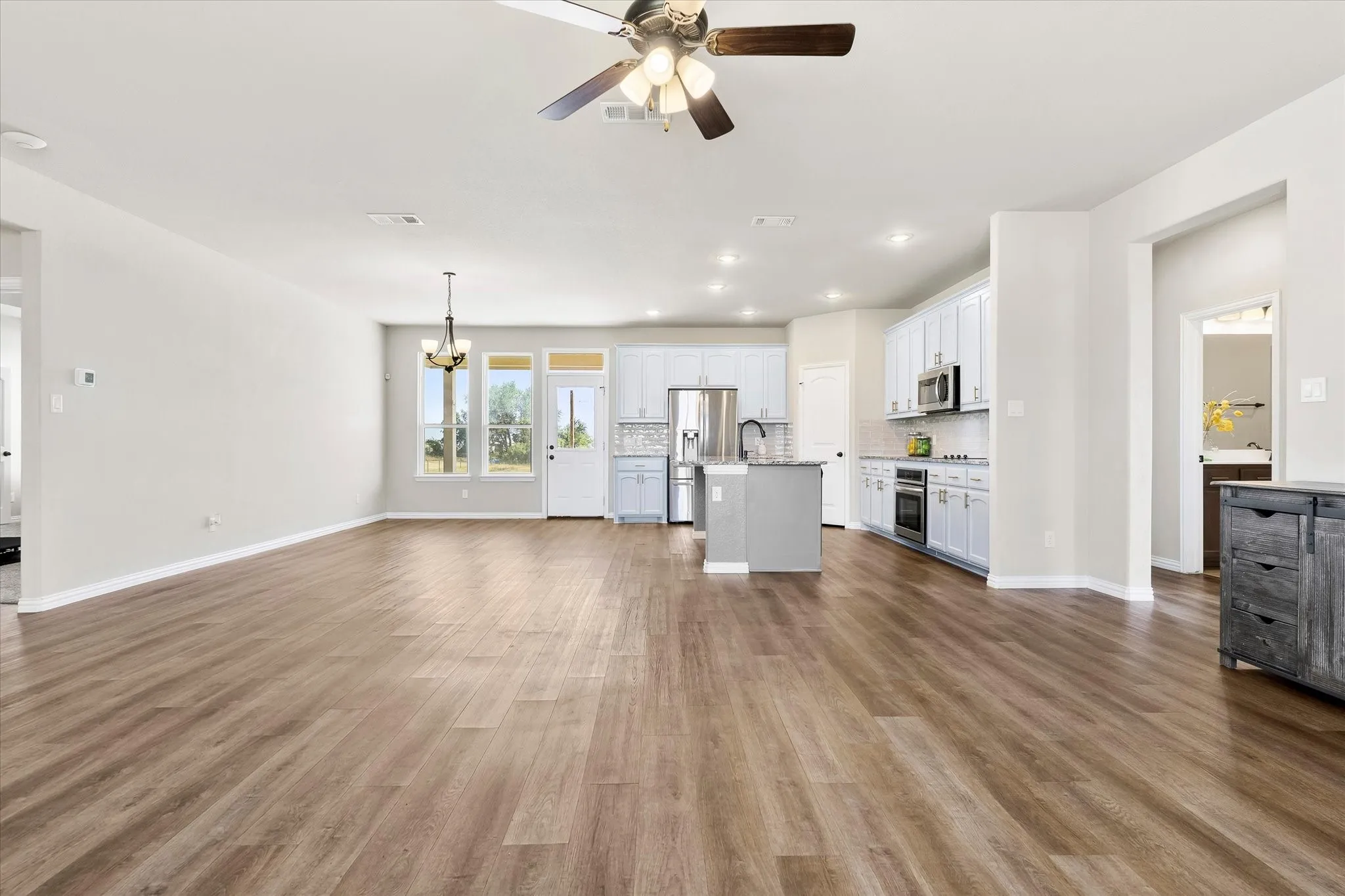 Wood-finish flooring throughout, recessed lighting, and a ceiling fan