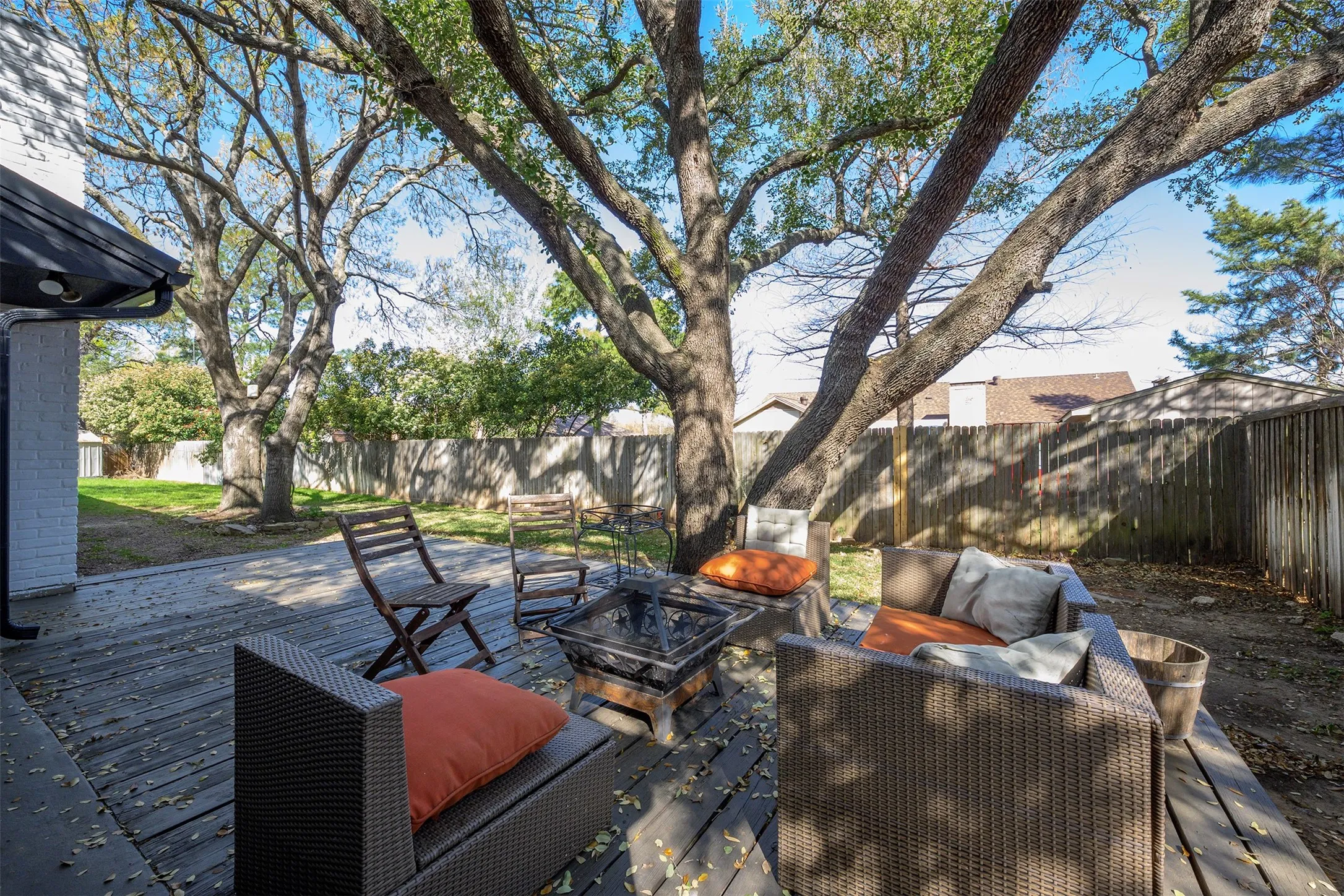 Expansive wood-finish deck with mature trees overhead