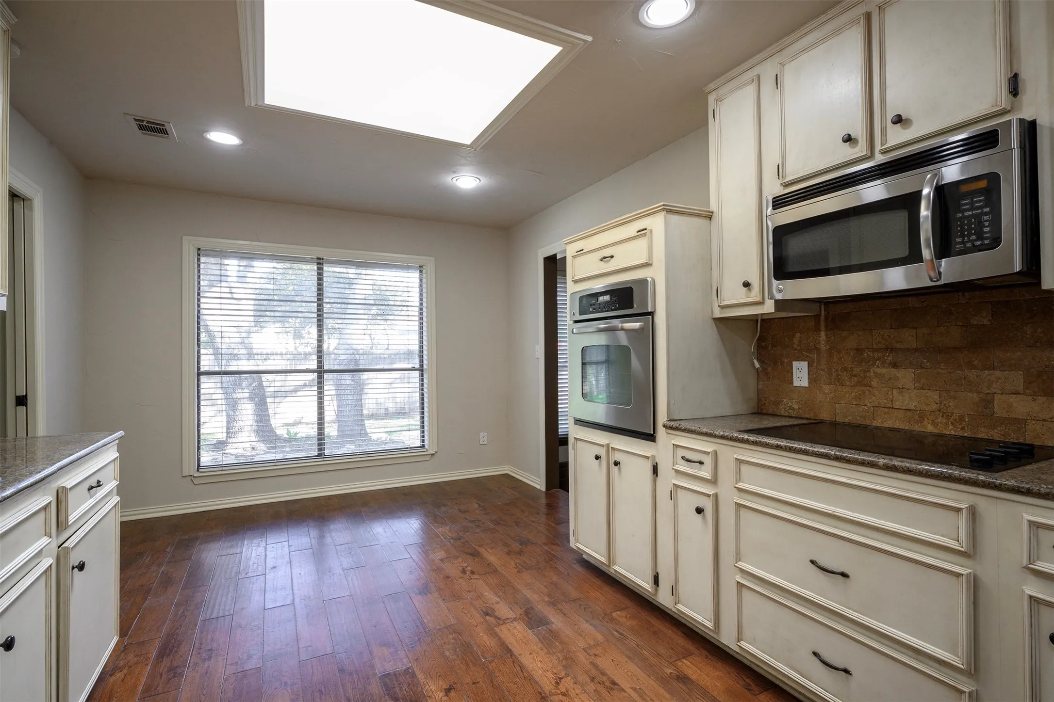 Kitchen featuring wood-finish flooring, recessed lighting, and a large window