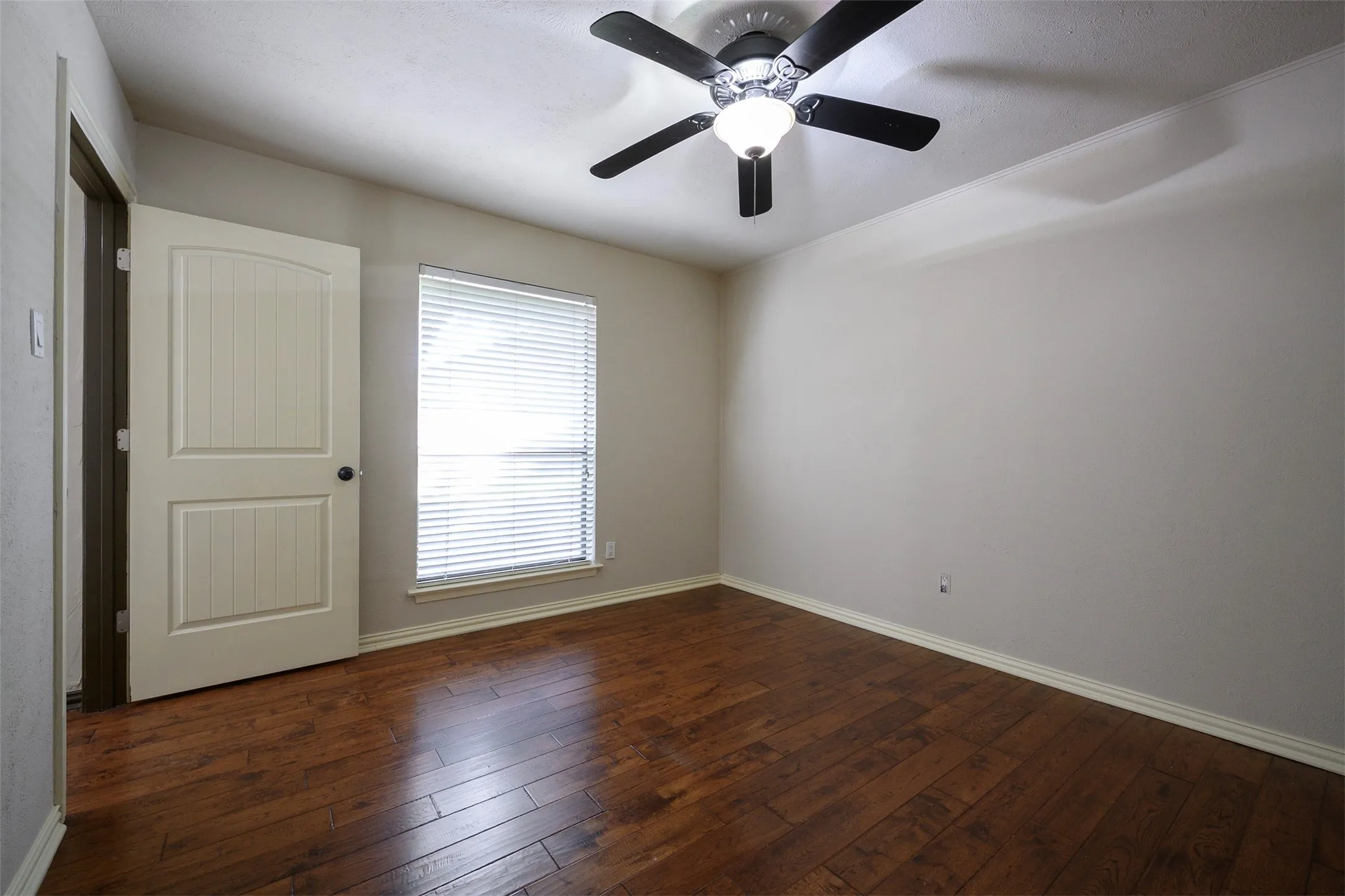 Room featuring wood-finish flooring, a vaulted ceiling, and a ceiling fan with integrated lighting