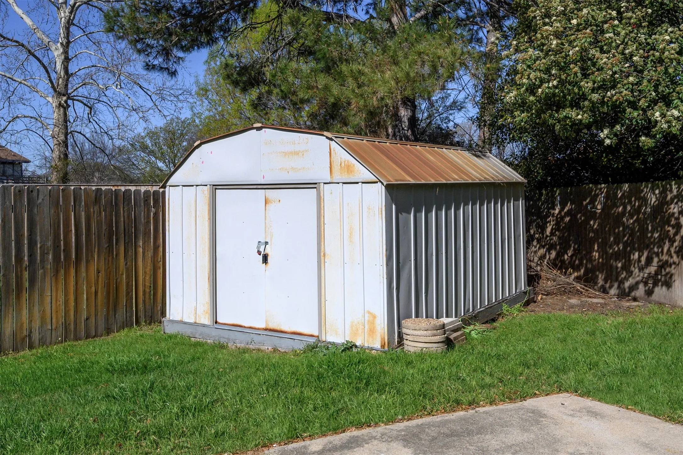 Metal storage shed with double doors and a corrugated metal roof