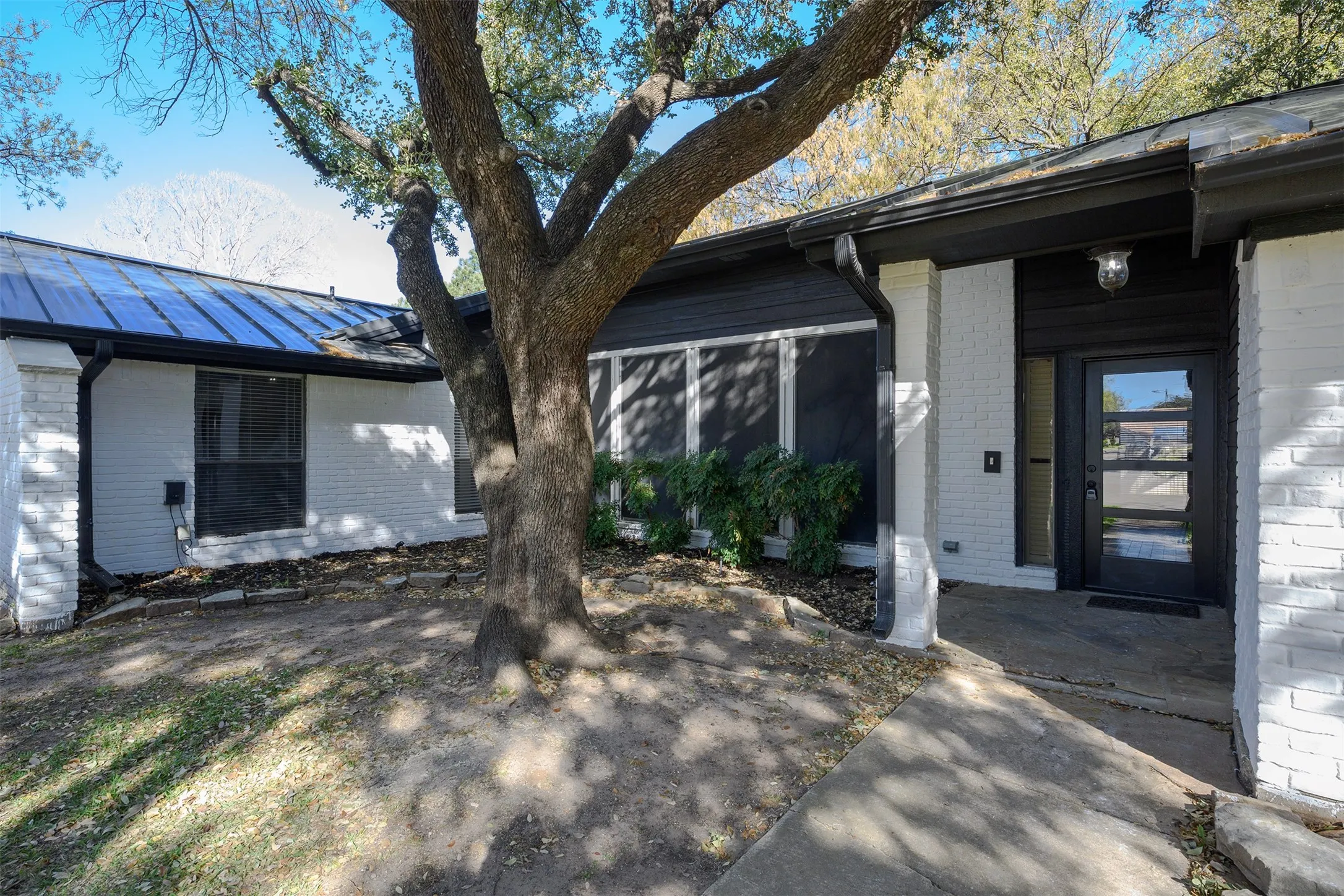 Modern exterior featuring white brick and dark horizontal siding