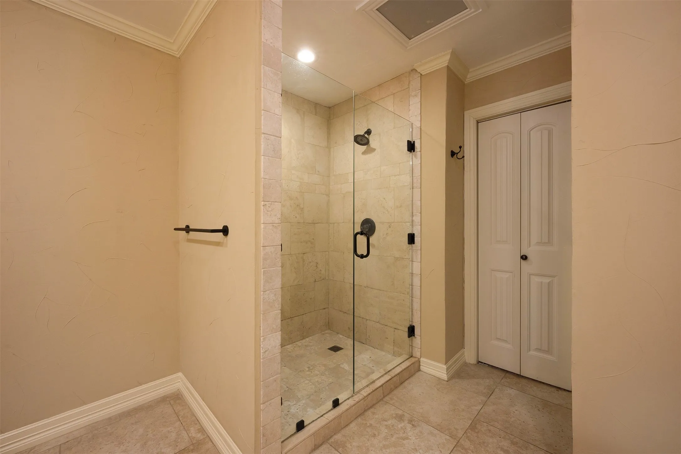 Glass-enclosed shower featuring a tiled interior, dark bronze fixtures, and a clear glass door