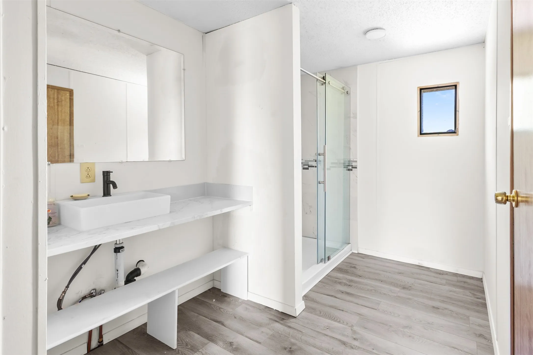 Bathroom featuring a rectangular vessel sink, dark-finish faucet, and a wall-mounted mirror