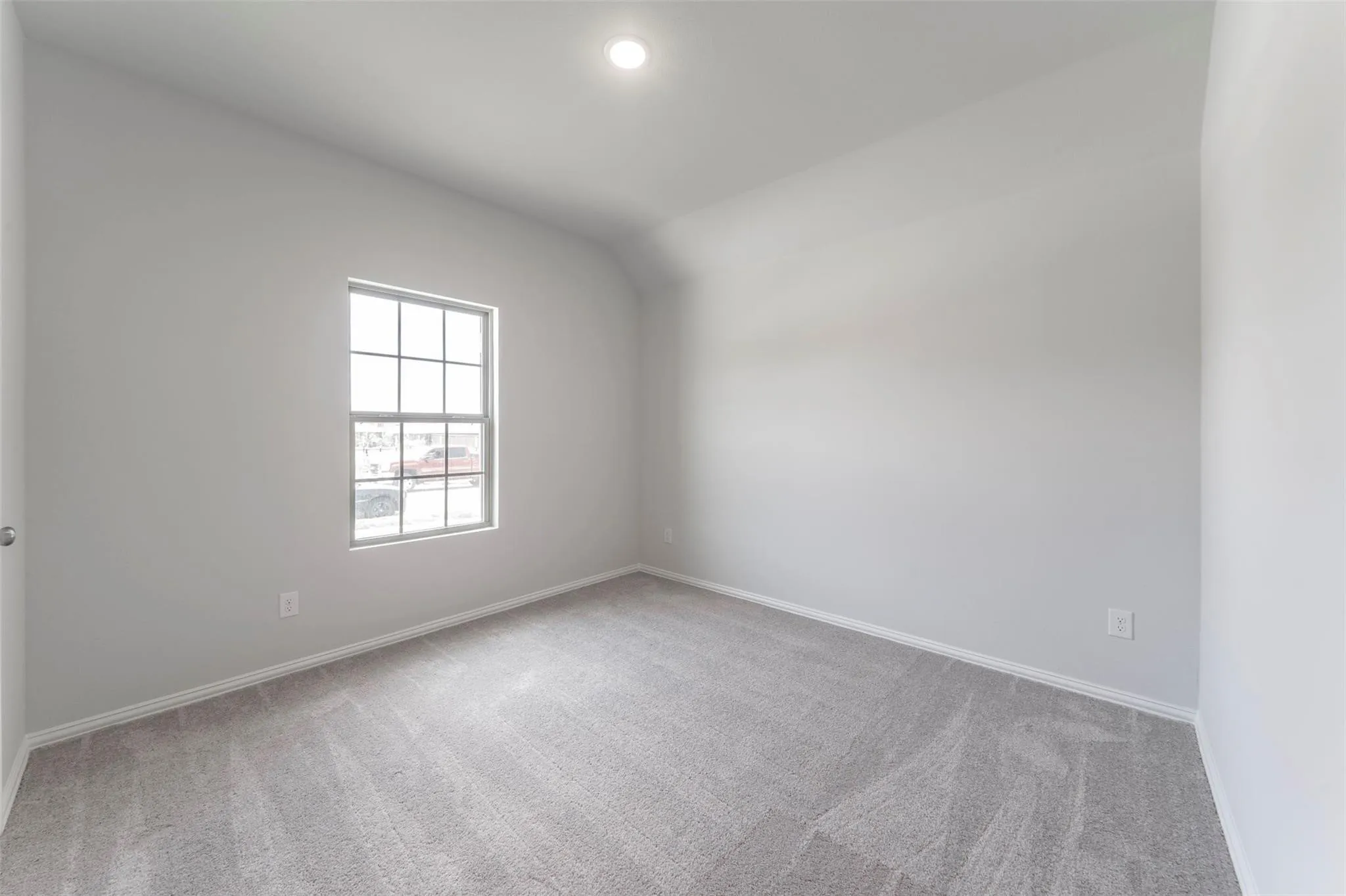 Room featuring a grid-pattern window, light gray carpeting, white baseboards, and recessed ceiling lighting