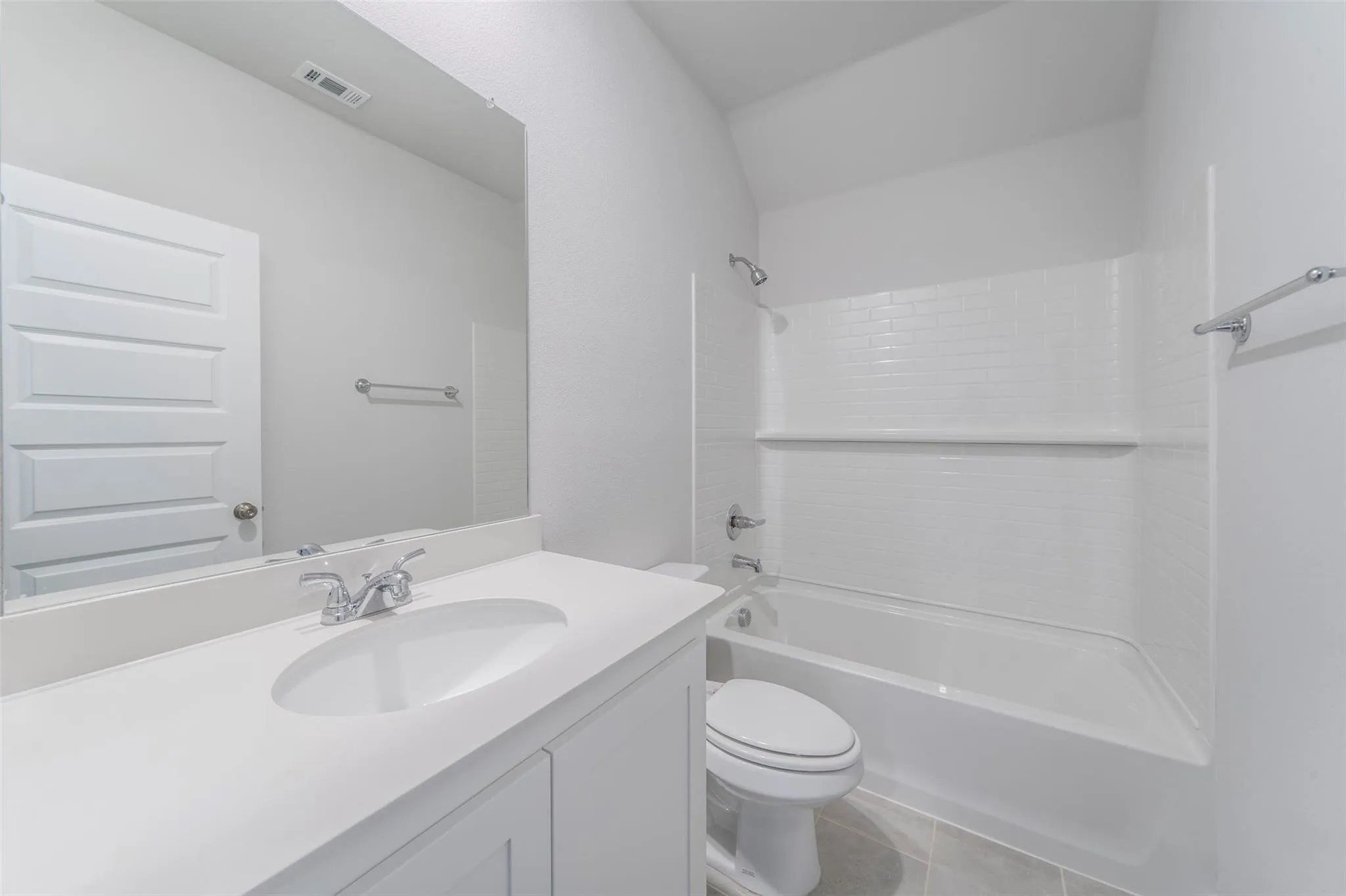 Bathroom featuring a vanity with an integrated sink, polished chrome faucet, and a wall-mounted mirror