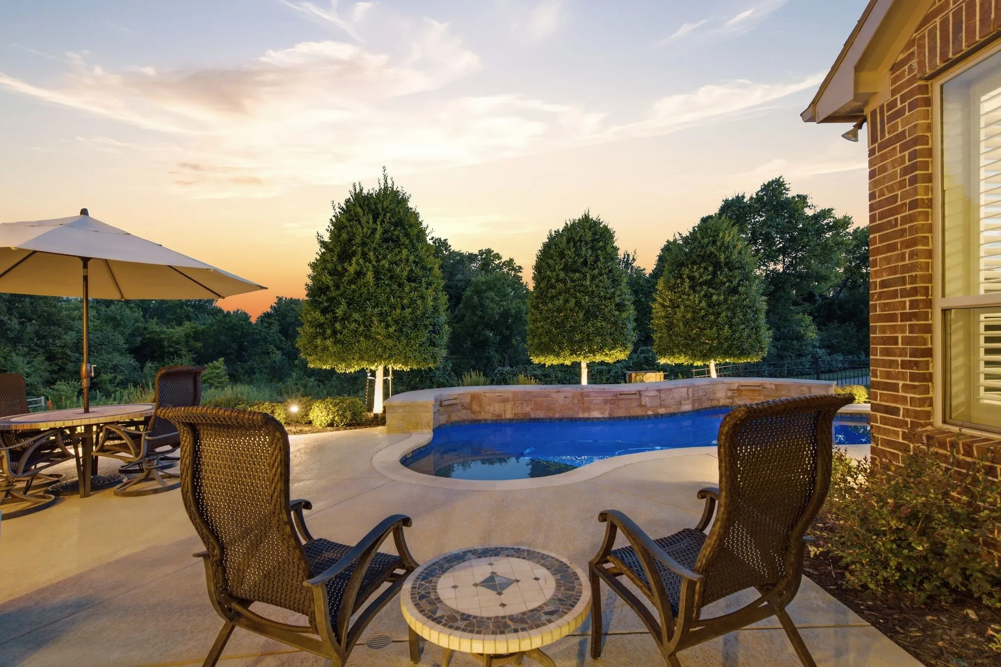 Curved swimming pool with an integrated stone waterfall feature
