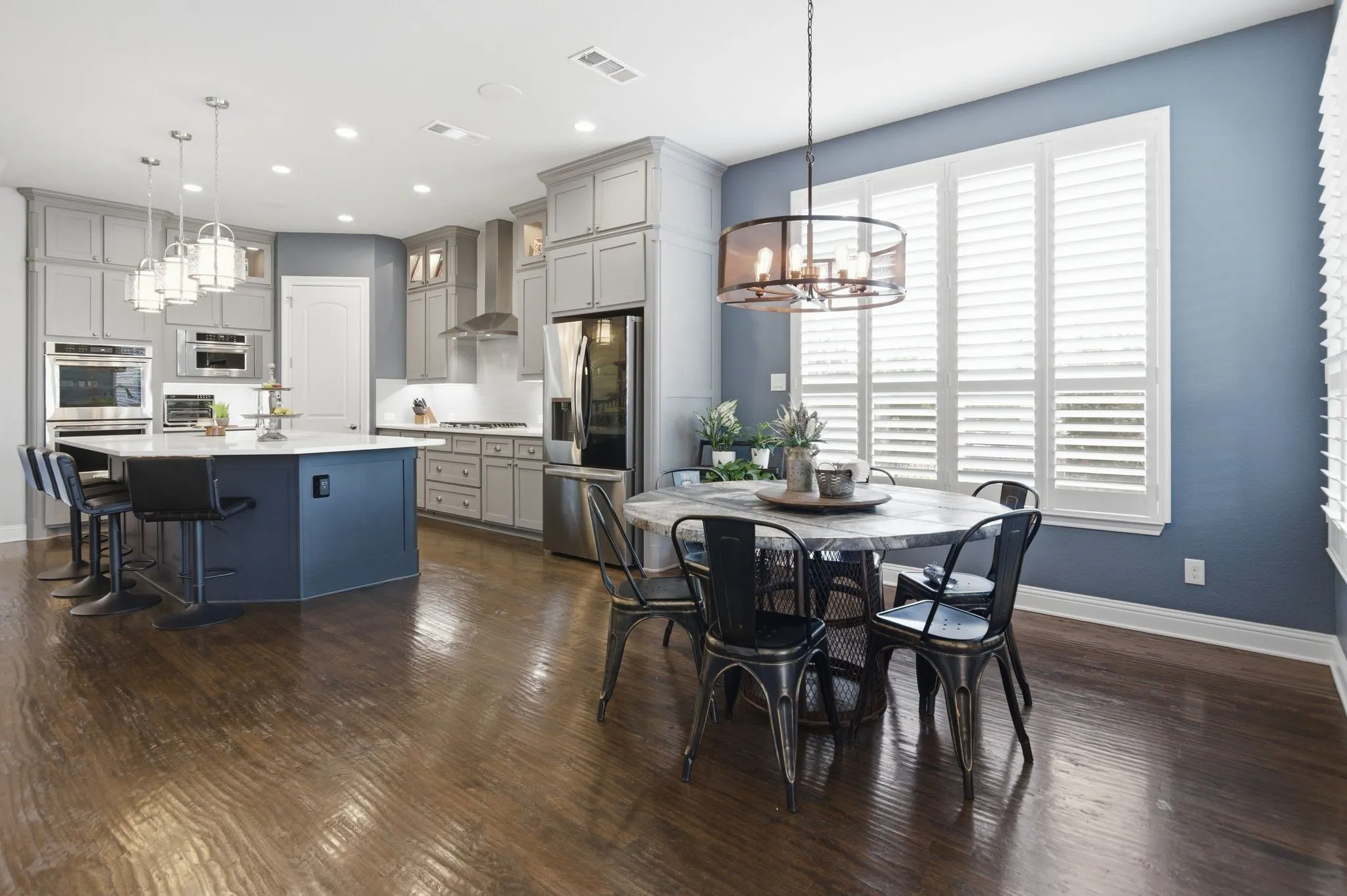Open-concept kitchen and dining area featuring rich wood-finish flooring