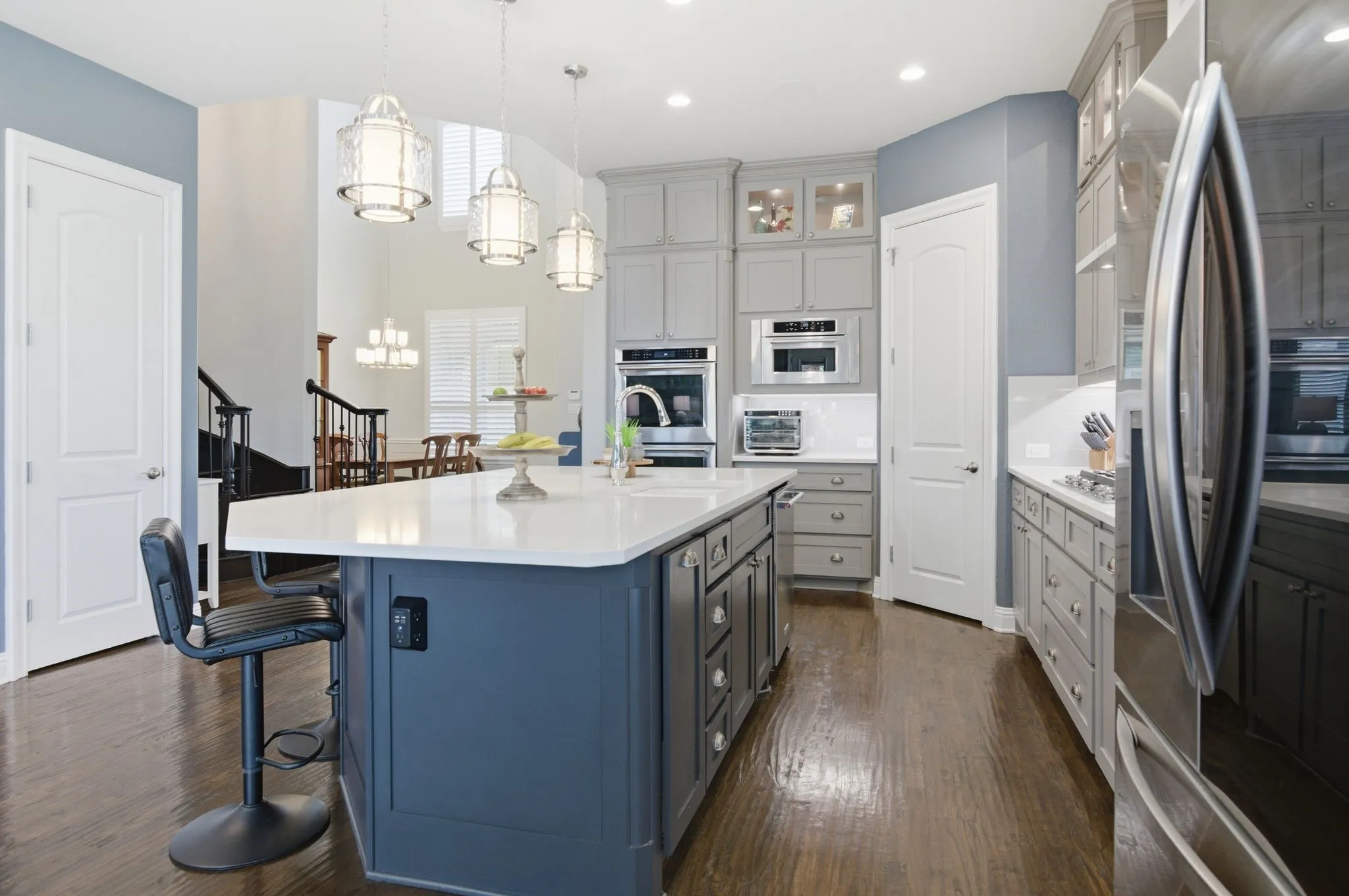 Kitchen featuring a substantial island with a white countertop and blue-painted base cabinetry