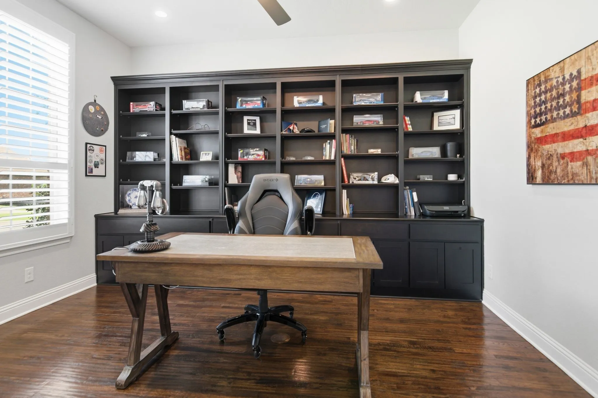 Built-in dark wood shelving unit with lower cabinetry, wood-finish flooring, recessed lighting, and a ceiling fan