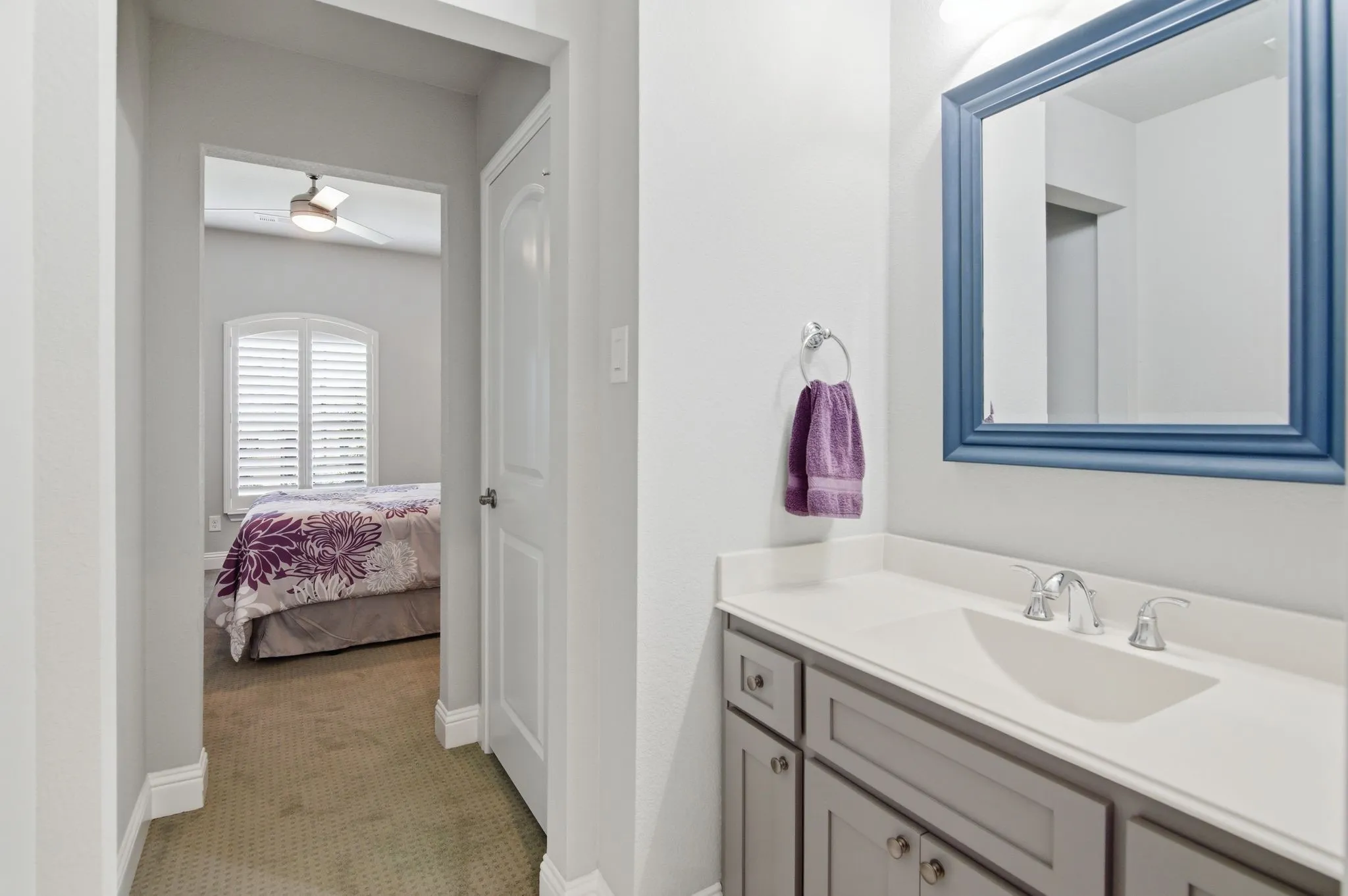 Bathroom vanity featuring a light countertop, integrated sink, and chrome faucet