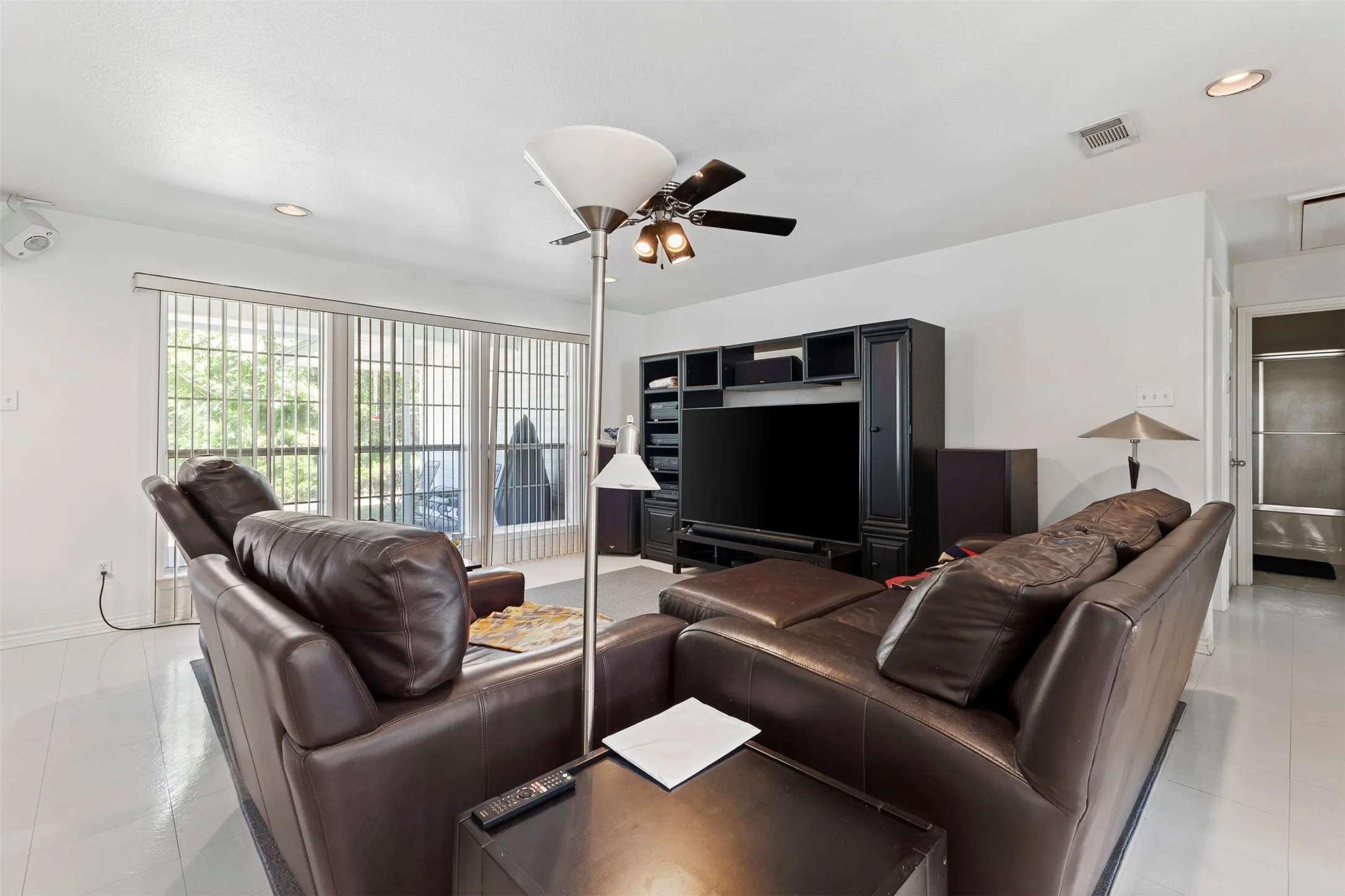 Living area featuring light-toned flooring, recessed lighting, and a ceiling fan